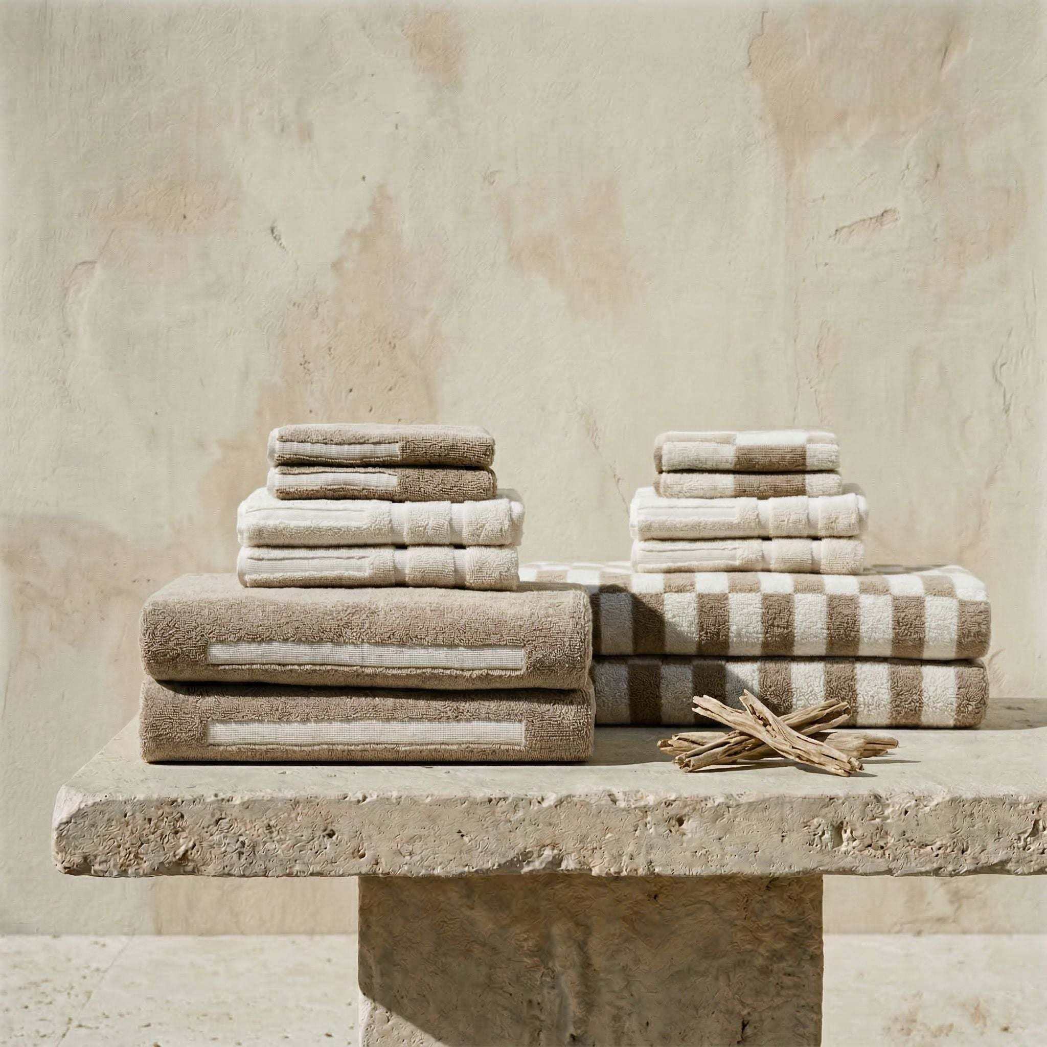 Australian Cotton towels in beige and cream tones with striped and solid patterns, soft cotton texture in stacked sets