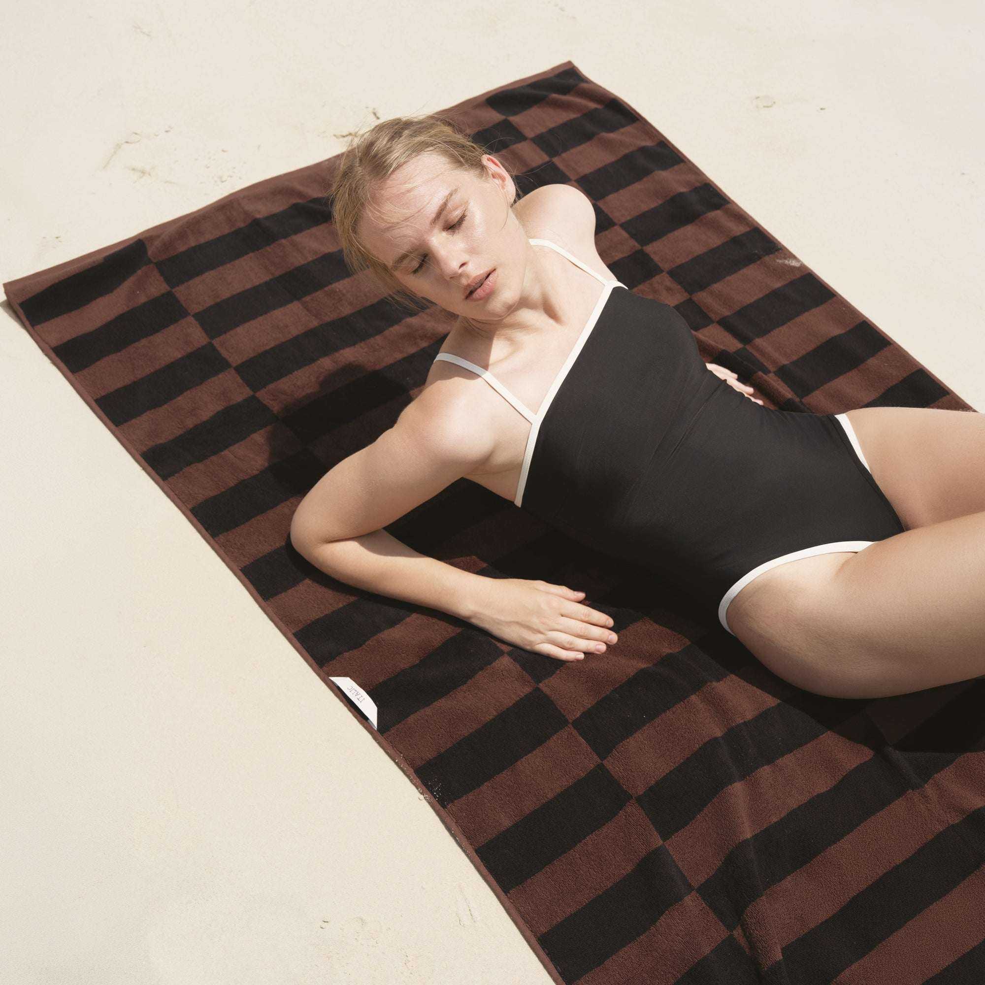 Australian Cotton towels in dark brown and black striped pattern, featuring a dense, plush texture ideal for beach or bath use