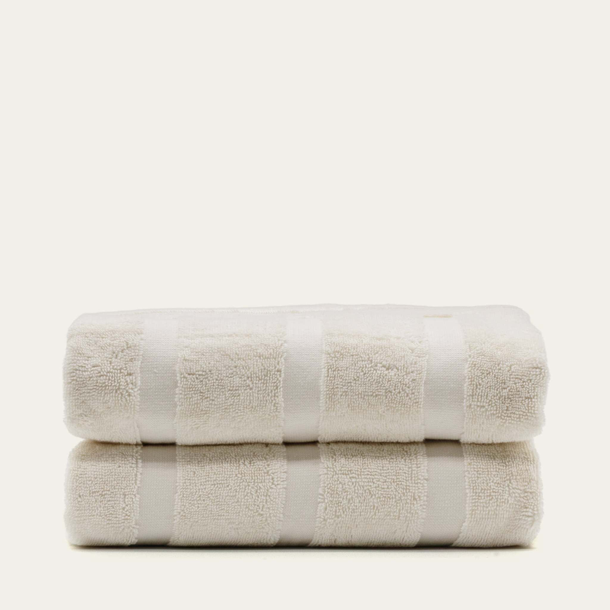 Stack of two plush ecru Australian Cotton towels with a subtle striped pattern and thick texture