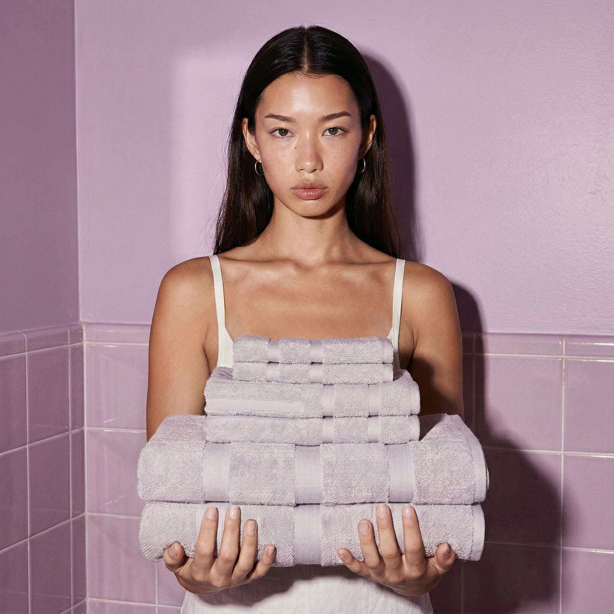 Australian Cotton towels in soft lilac shade featuring dense, plush 600 GSM cotton with geometric pattern, stacked neatly in hands