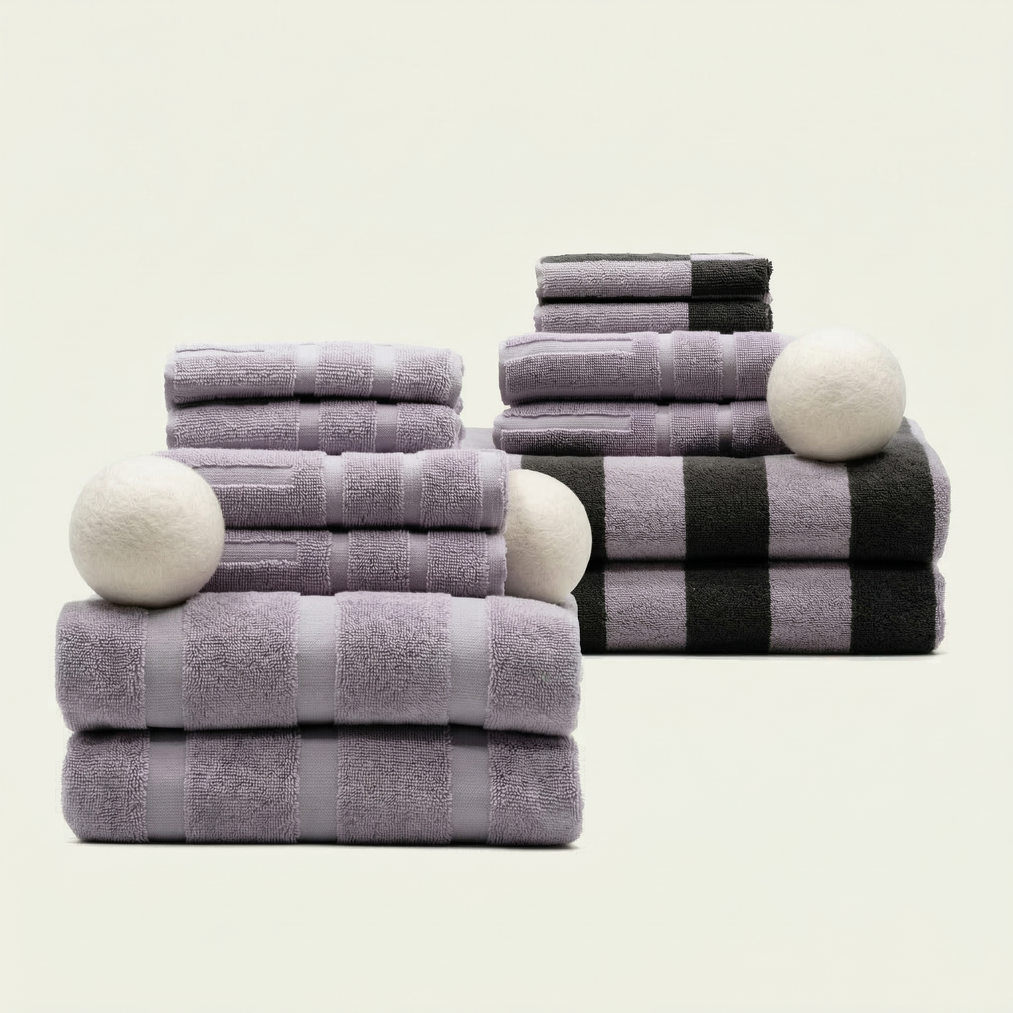 Stacked Australian Cotton towels in lilac and black with geometric patterns and plush texture, featuring soft round white accents