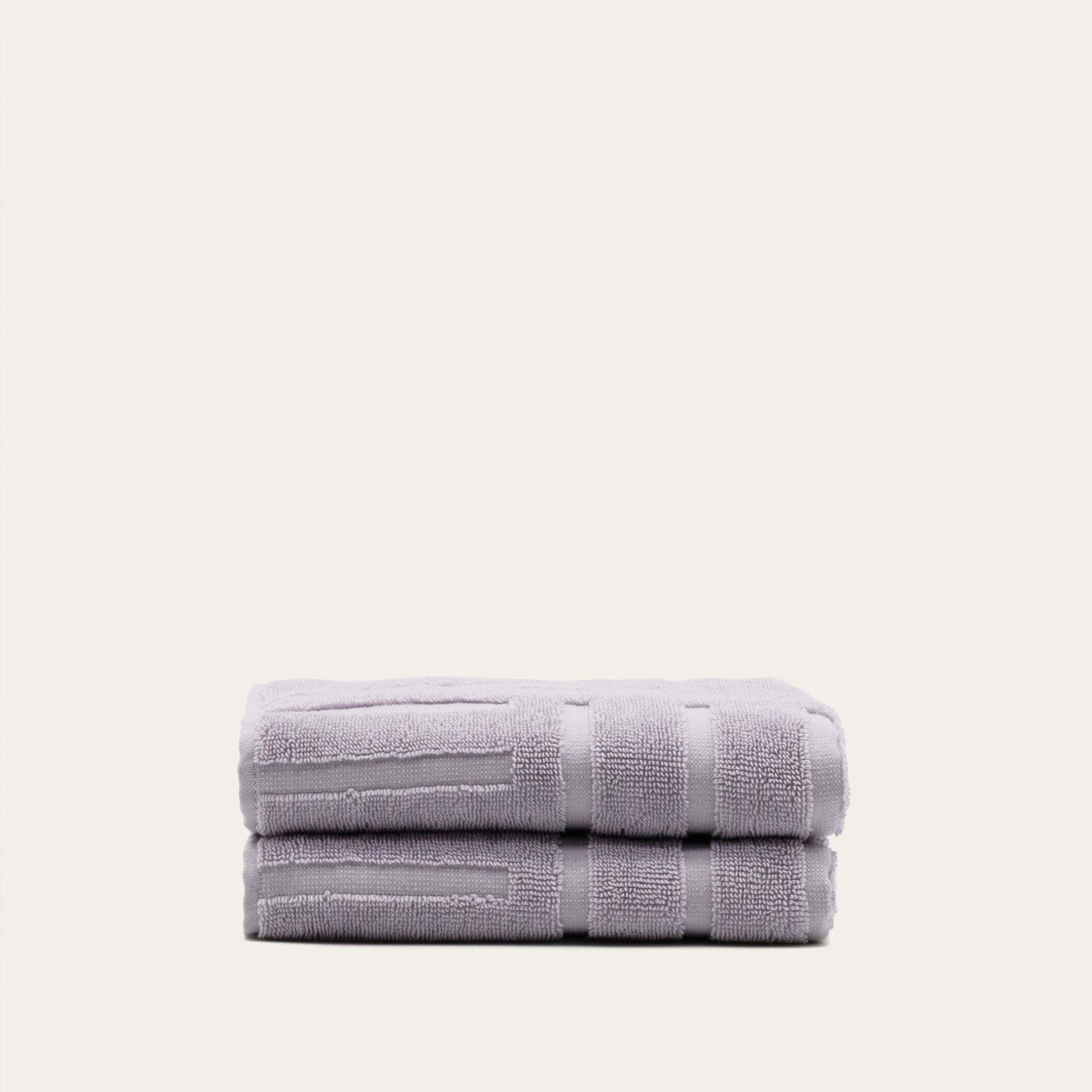 Stacked lilac Australian Cotton towels with geometric pattern, ultra-soft and dense 600 GSM fabric, featuring a functional locker loop