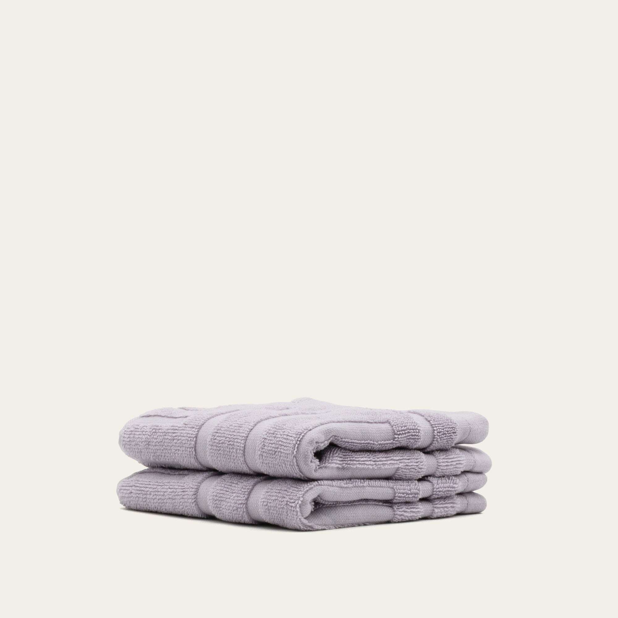 Set of soft lilac Australian Cotton towels folded neatly, featuring a thick plush texture and subtle geometric pattern