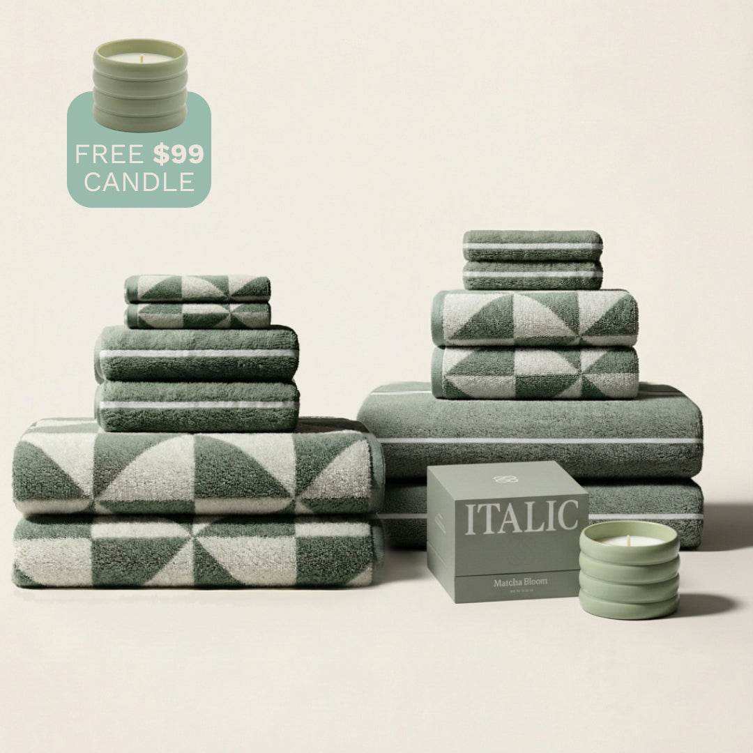 Australian Cotton towels in sage and ecru colors with geometric patterns, stacked with accompanying green ceramic candles
