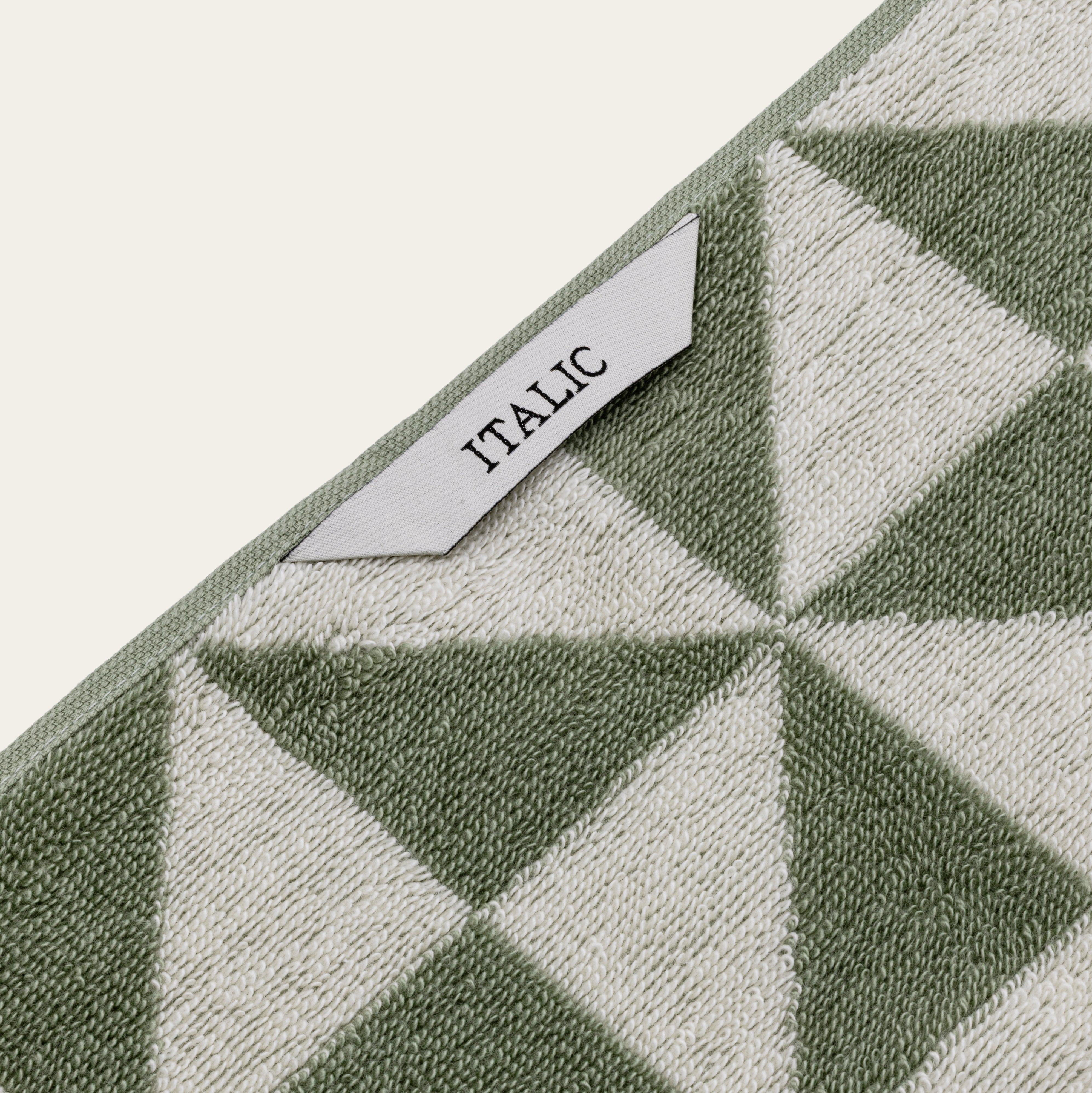 Australian Cotton Towels in sage green and cream cotton, featuring a plush woven triangular pattern and sewn label