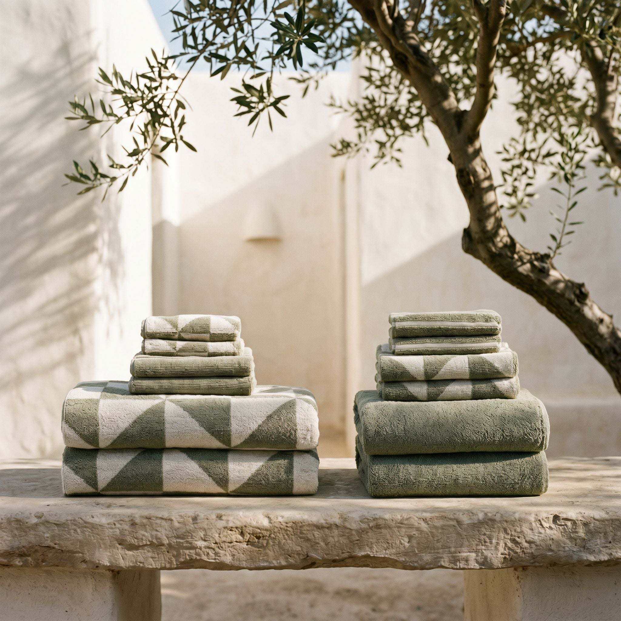 Stacked Australian Cotton towels in sage green with geometric patterns and solid texture, showcasing soft and plush fabric