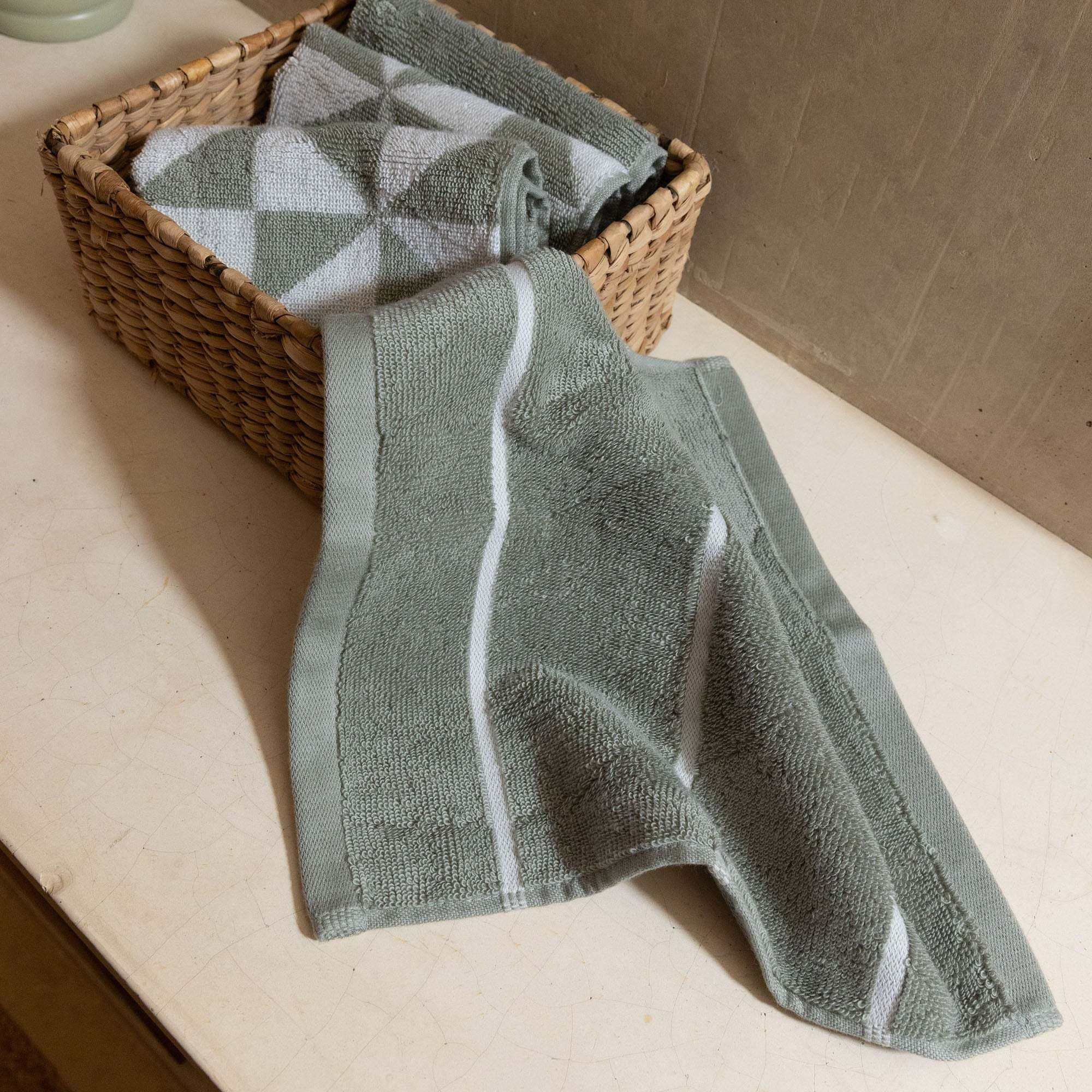 Australian Cotton towels in sage green with white stripes and geometric patterns, made of soft, plush cotton with a visible texture