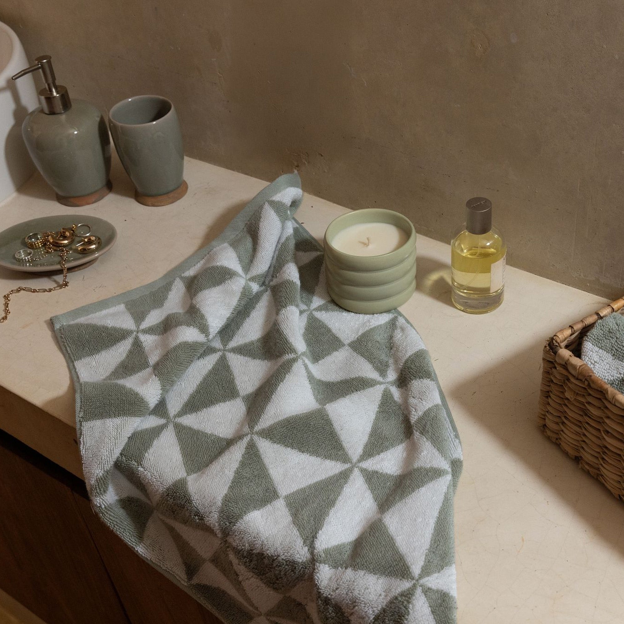 Australian Cotton Towels in sage green and white plush cotton, featuring a bold repeating triangular pattern