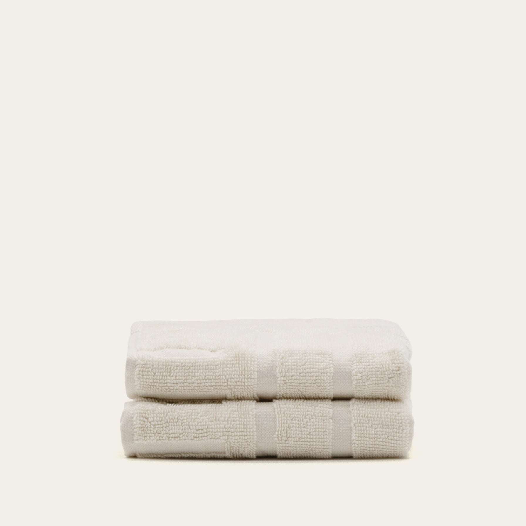 Set of two soft and absorbent ecru Australian Cotton towels with a textured stripe pattern and thick plush pile