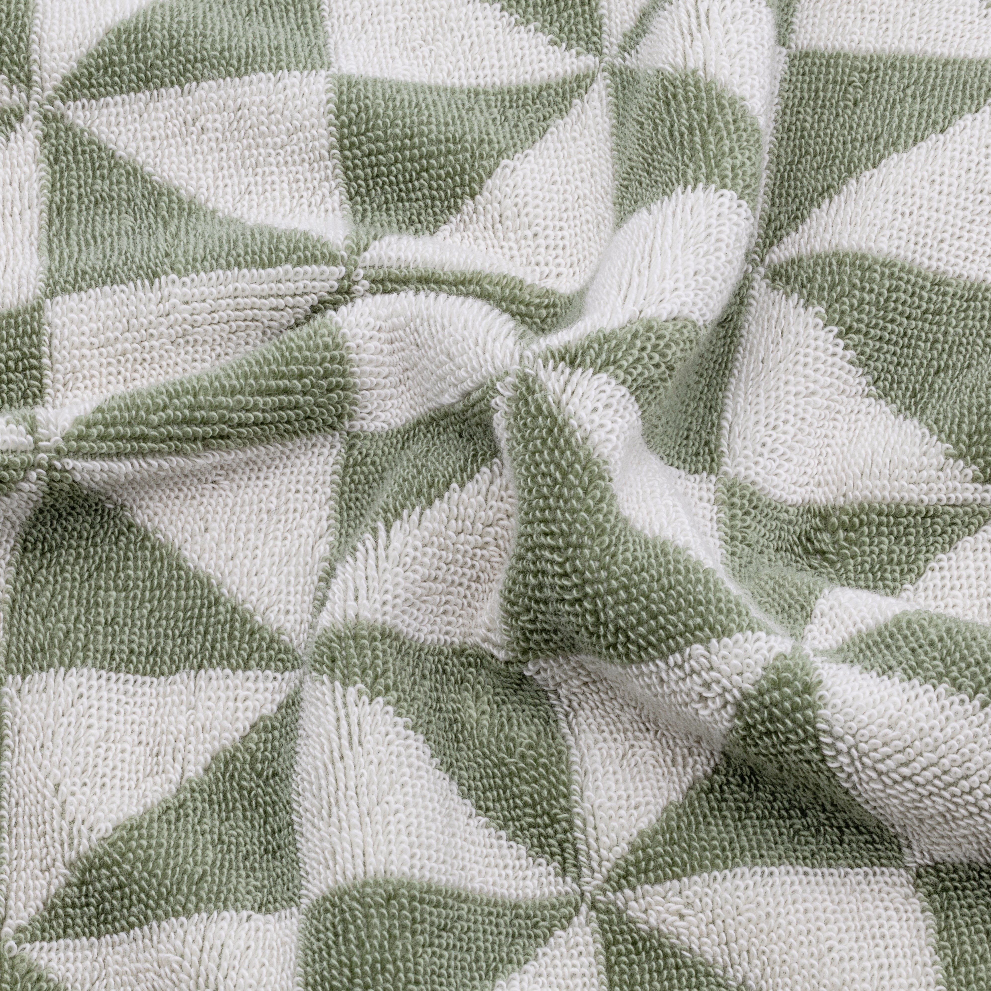 Australian Cotton Towels in plush white and sage green cotton with a bold geometric triangular pattern and textured pile