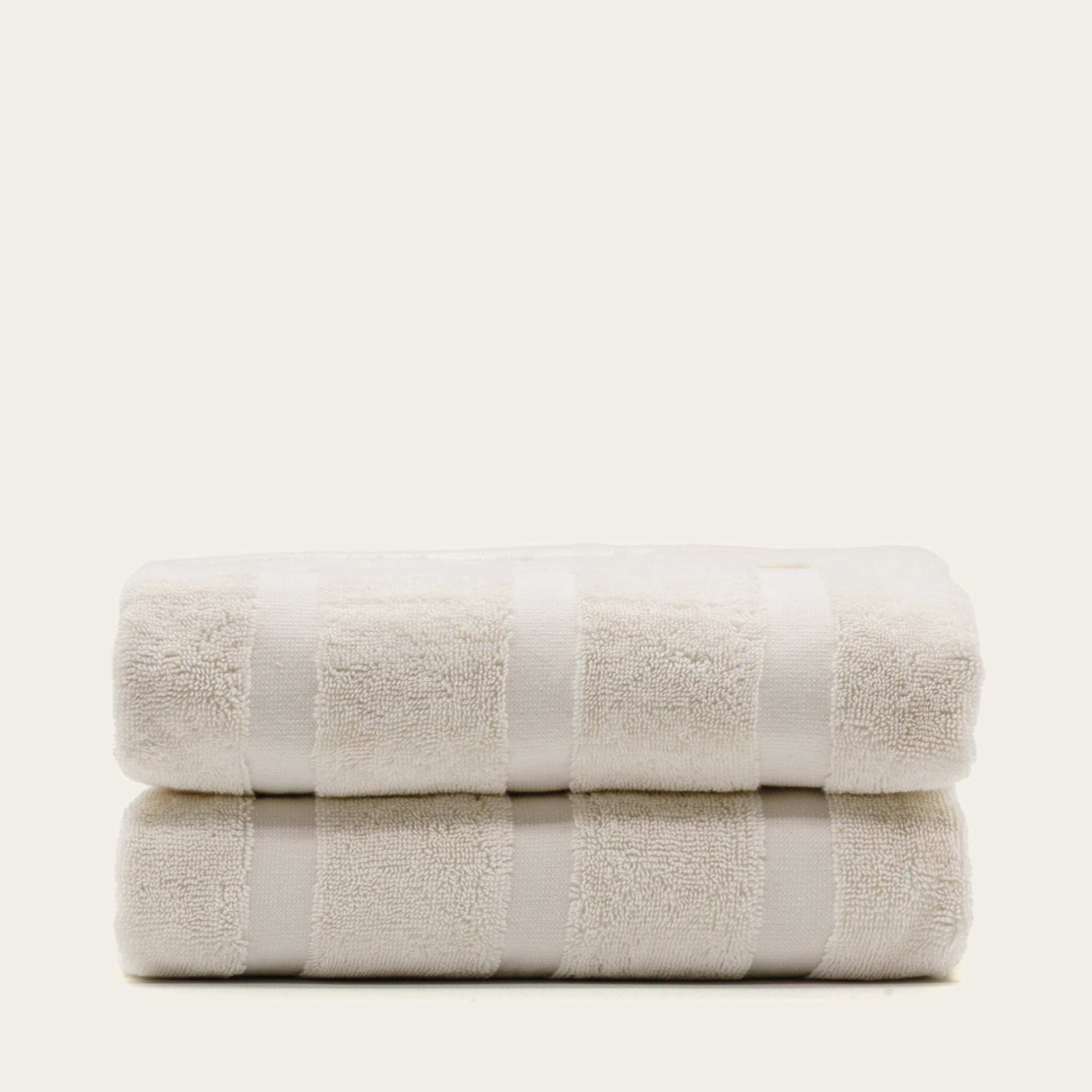 Stacked white Australian Cotton towels with a subtle striped pattern, plush and soft texture, high GSM