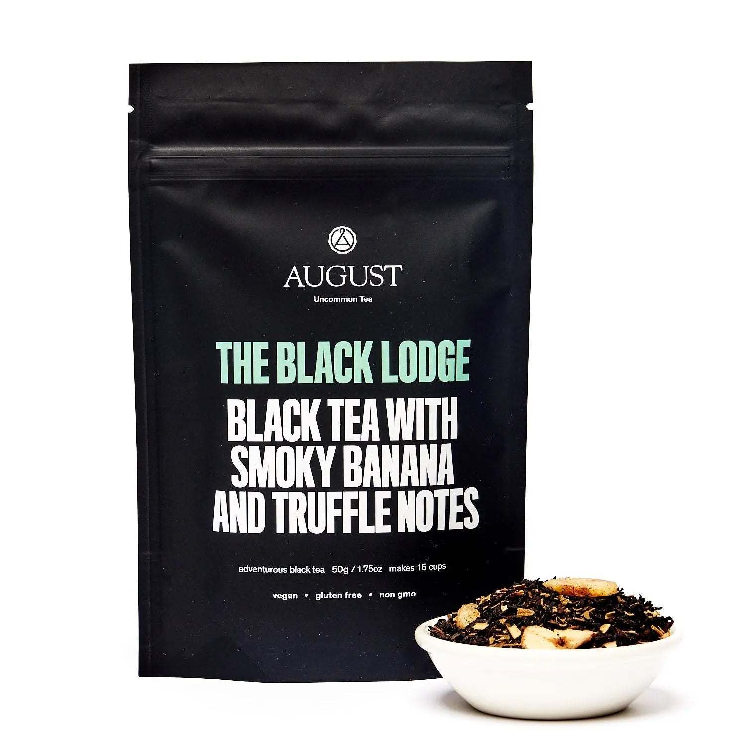 Black Lodge - Smoky Banana Black Tea in a black pouch with smoky banana and truffle notes, beside loose tea in a white bowl