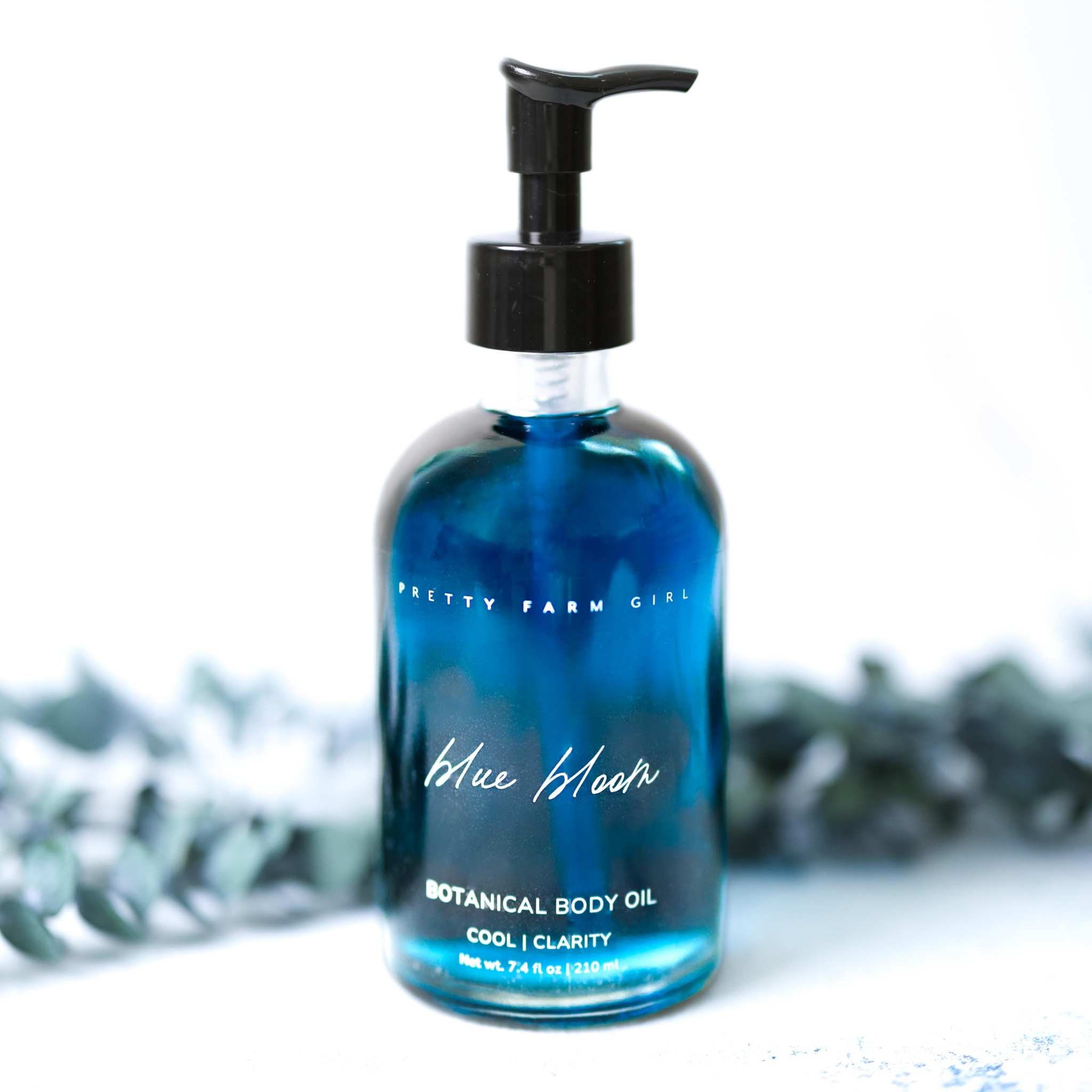 Blue Bloom Botanical Body Oil in a blue glass bottle with black pump and botanical label lettering