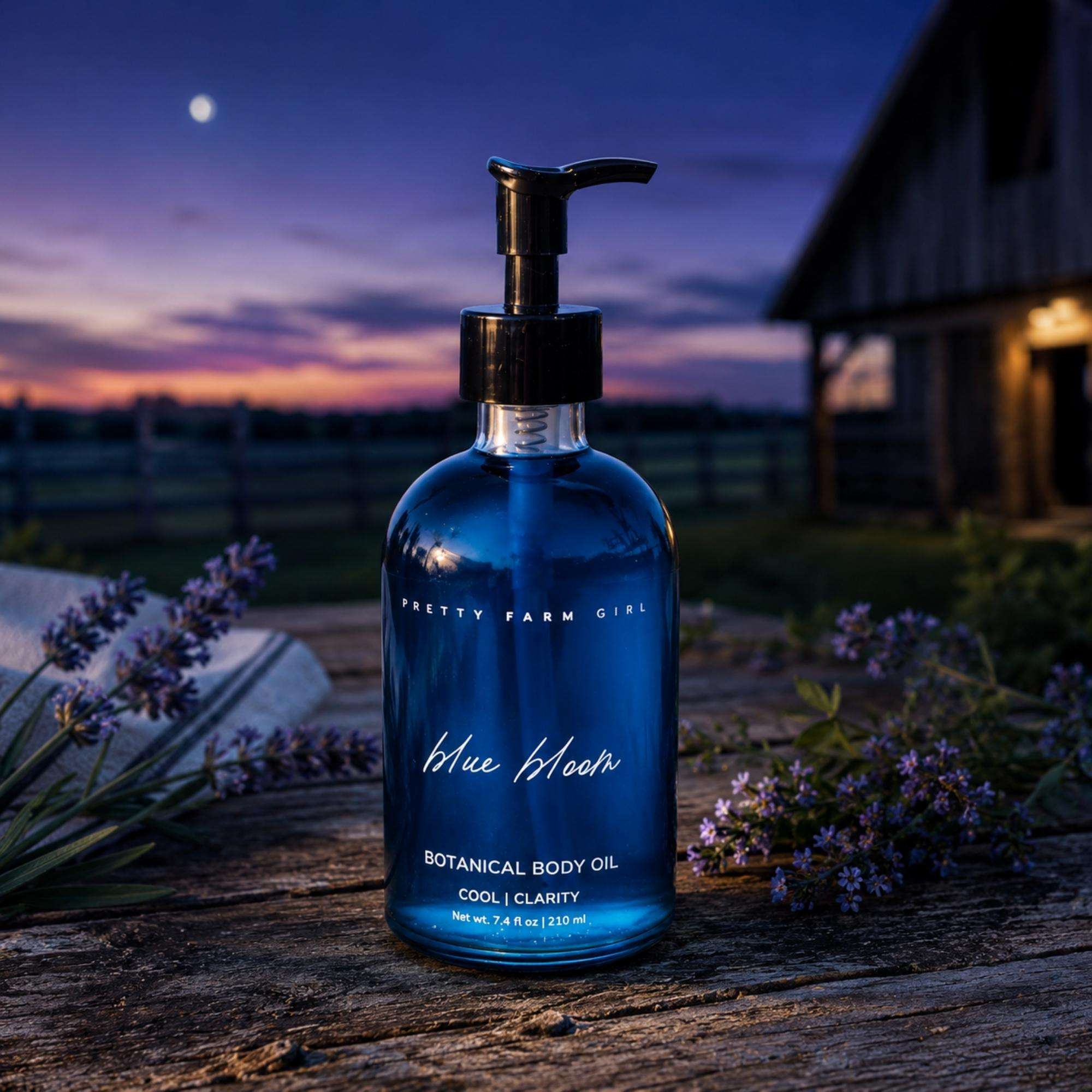 Blue Bloom Botanical Body Oil in a cobalt blue glass bottle with black pump and botanical label lettering