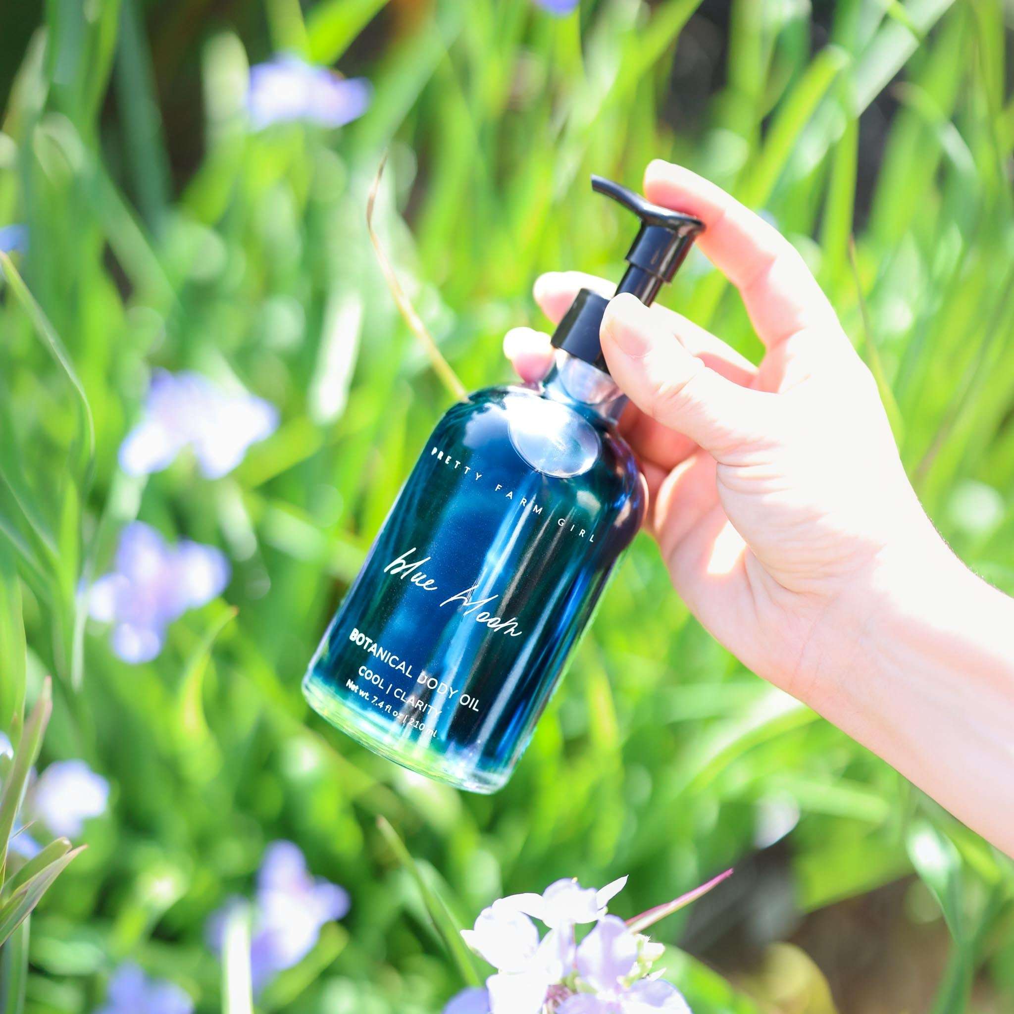 Blue Bloom Botanical Body Oil in a deep blue glass bottle with black pump and botanical label
