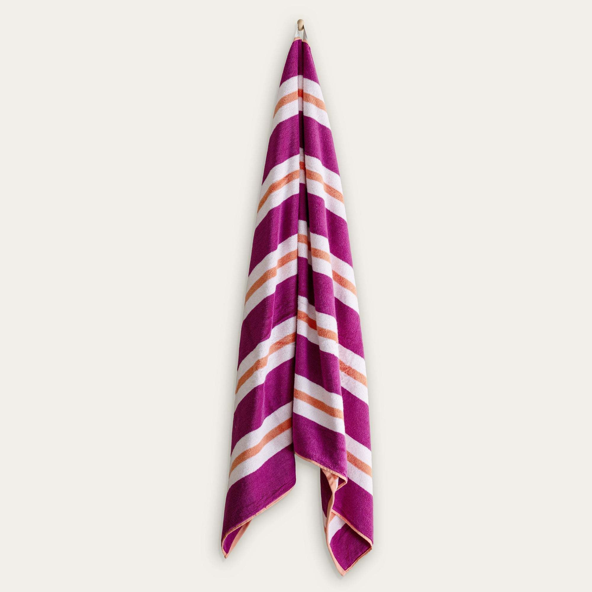 Bondi Australian Cotton beach towel in vivid magenta with bold white and peach diagonal stripes and a plush woven texture