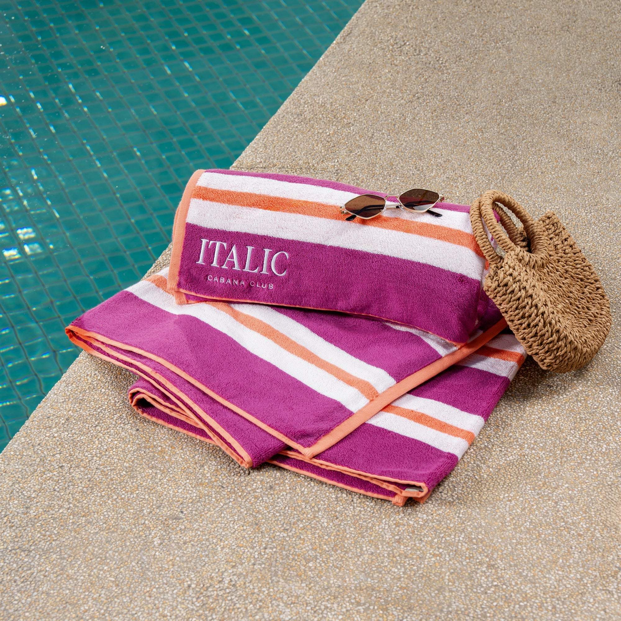 Bondi Australian Cotton beach towel in magenta with bold white and orange stripes and a matching folded cushion