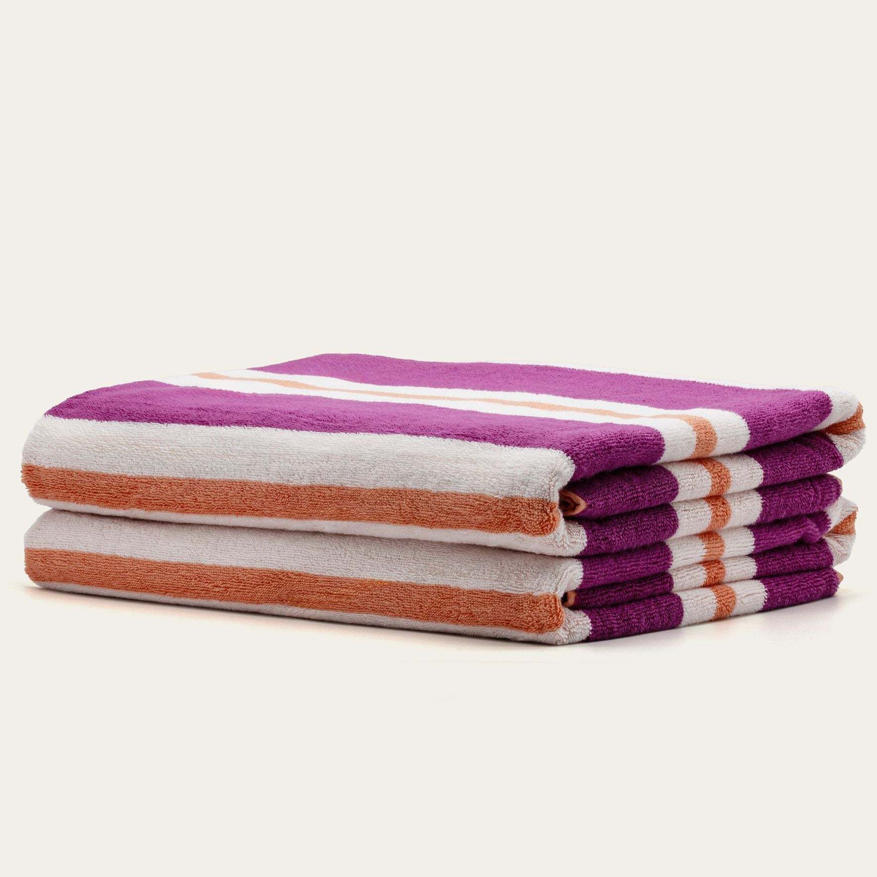 Bondi Australian Cotton beach towels in plush white, orange, and purple stripes, stacked in a folded set
