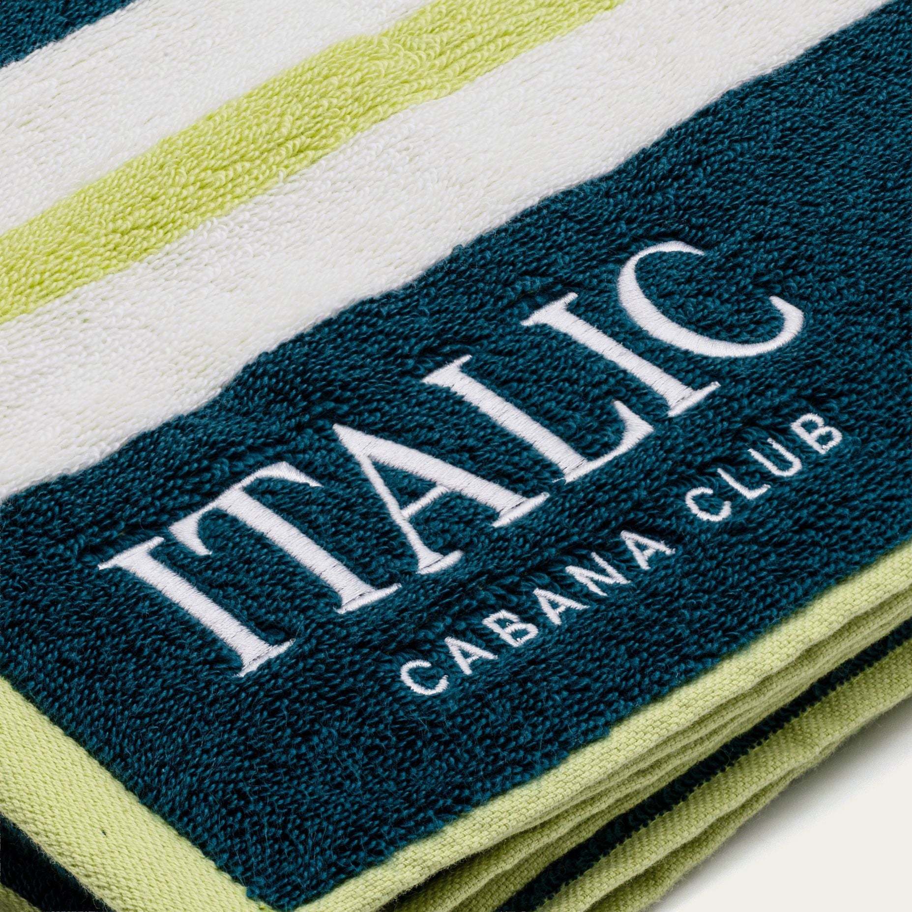 Bondi Australian Cotton beach towel with white and lime-green stripes, dark teal embroidered branding and plush terry texture
