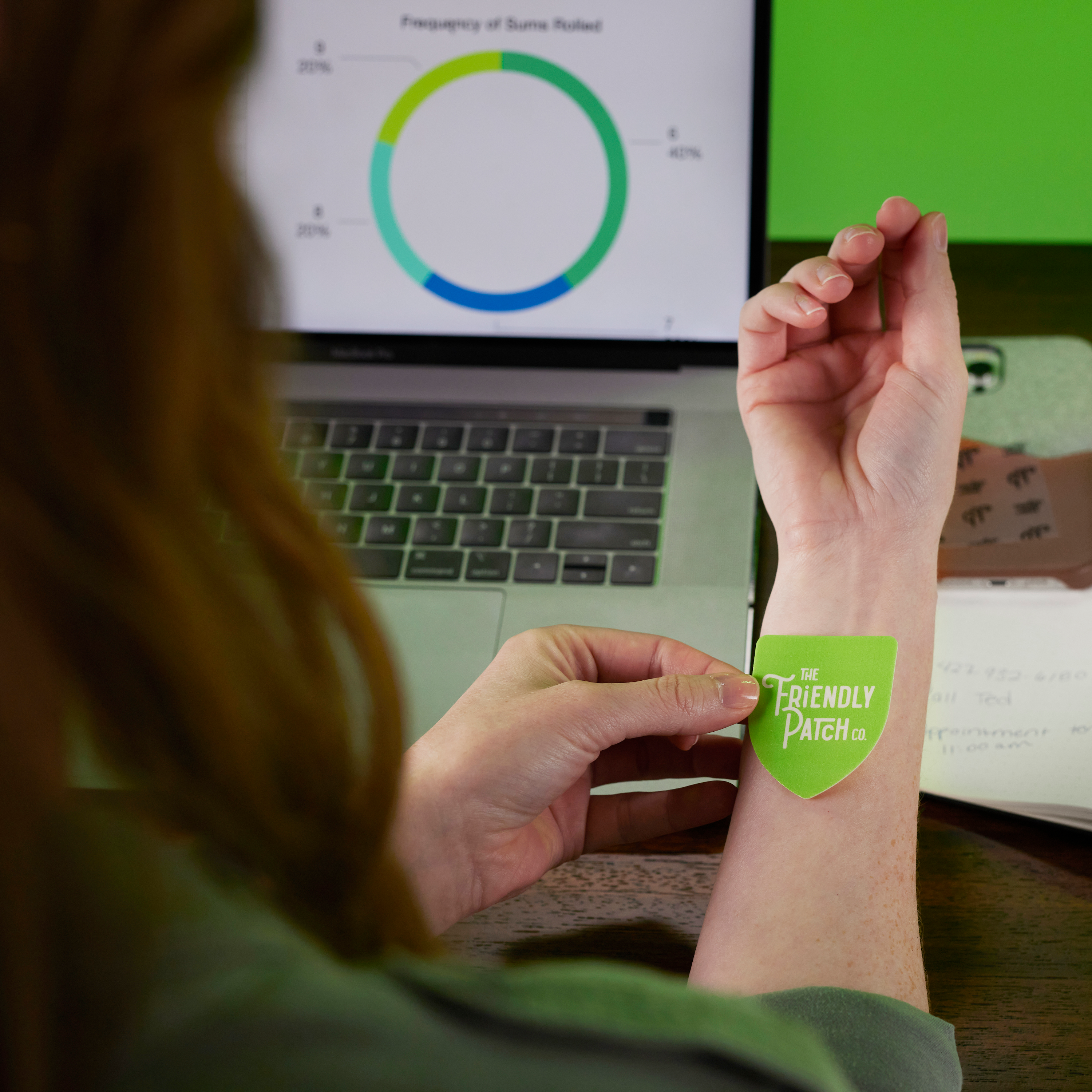 Boost Energy Patches green adhesive patch with Friendly Patch logo applied to a person's wrist
