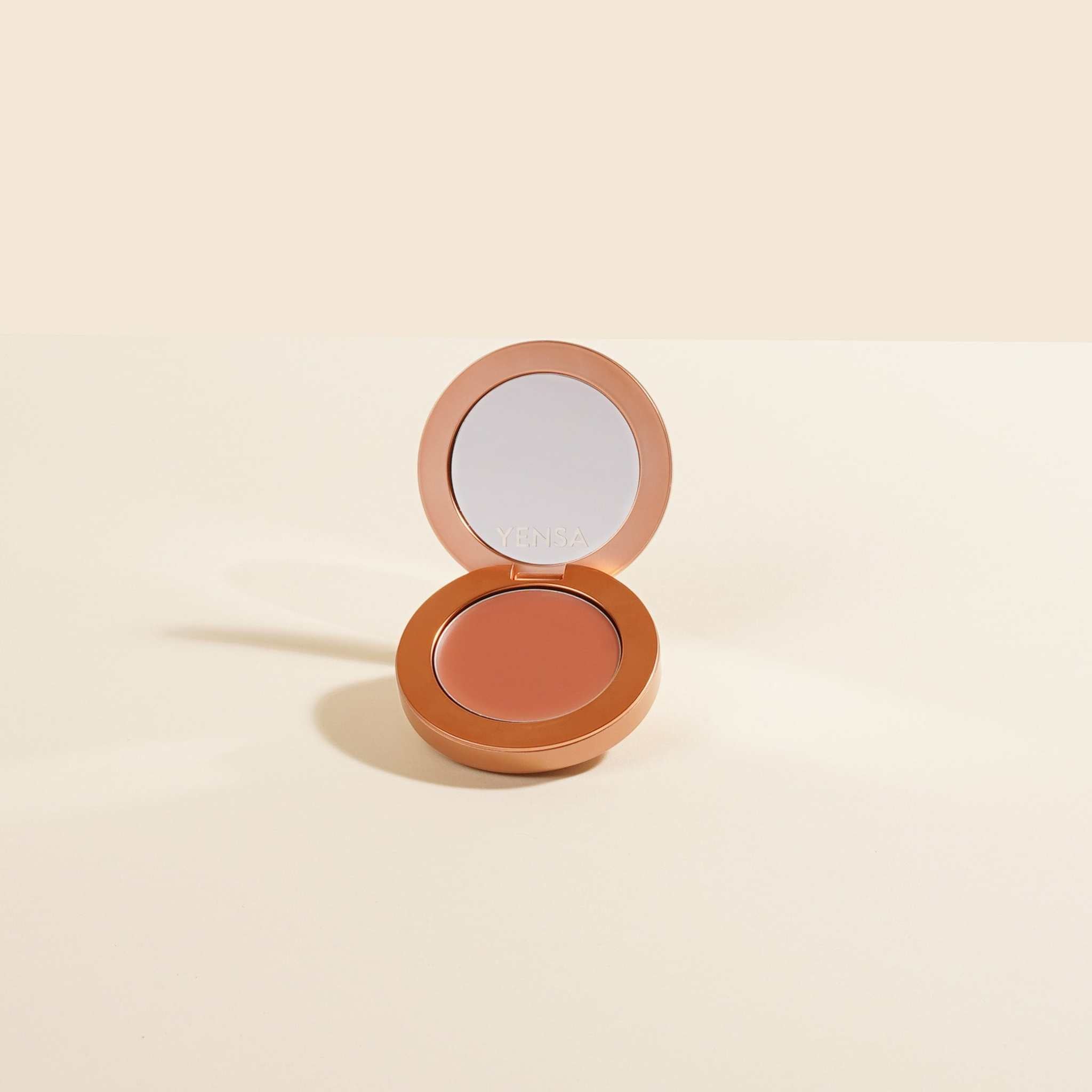 Buildable Cream Blush in a warm terracotta shade, housed in an open copper-toned compact with a mirror