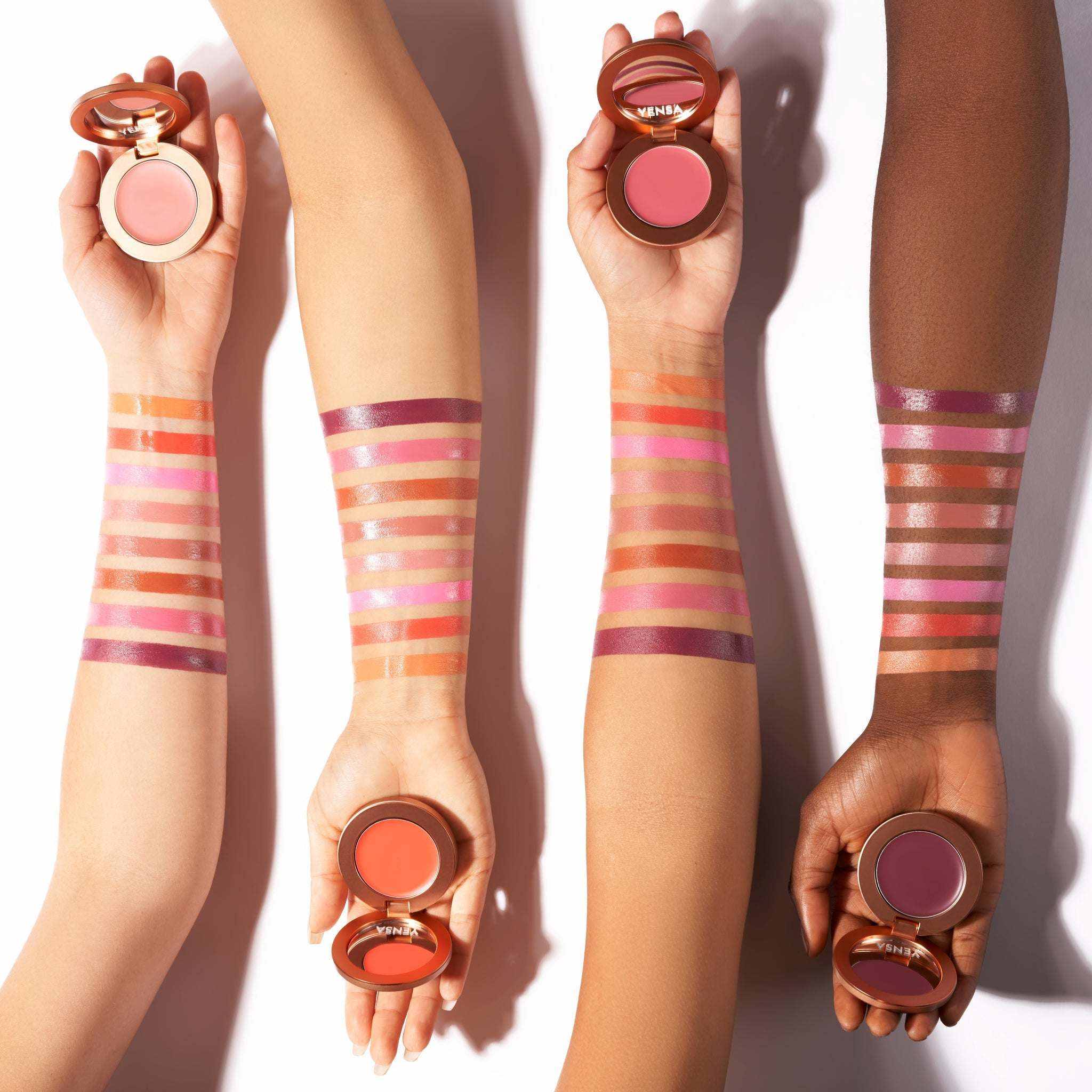 Buildable Cream Blush in open compacts, featuring silky cream shades from pale pink to coral and plum tones