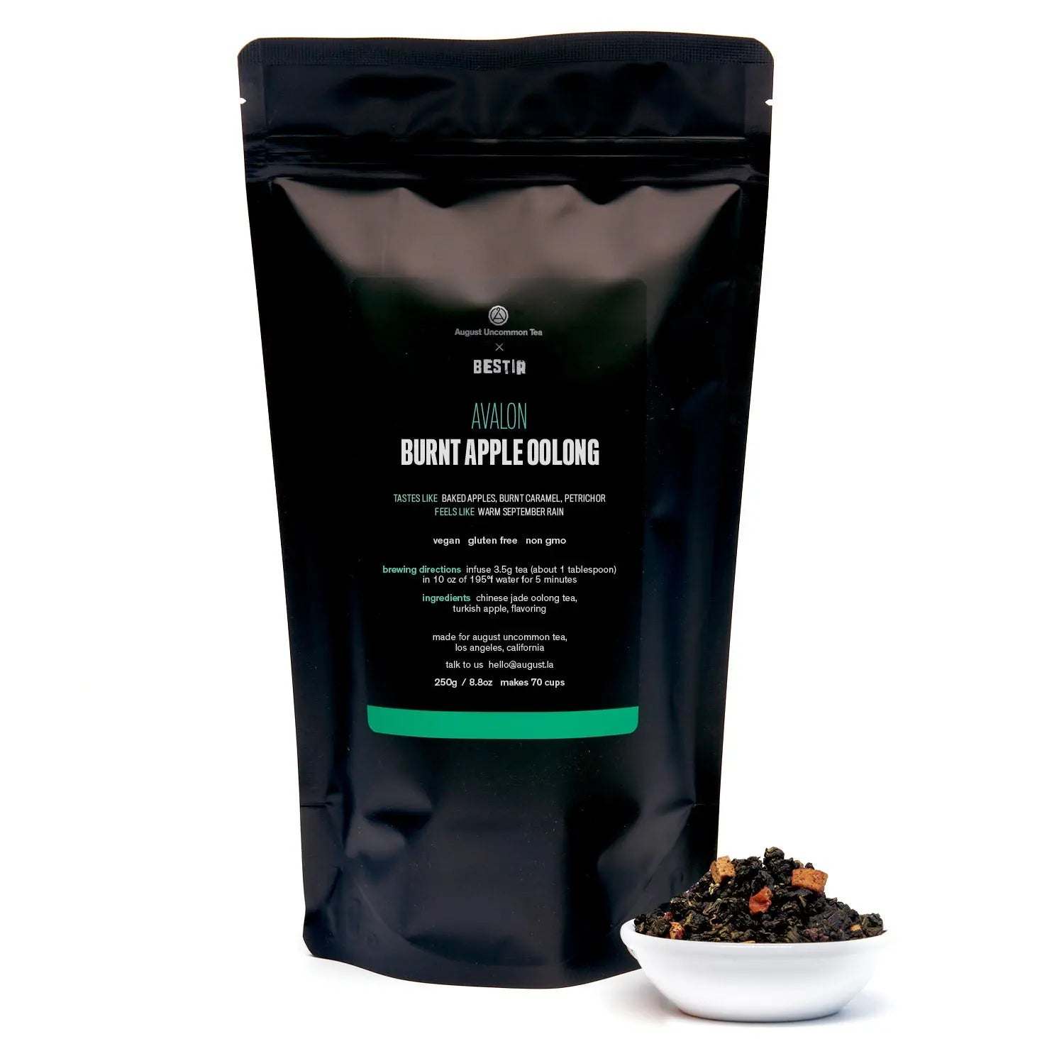 Burnt Apple Oolong Tea in a black resealable pouch, with dark loose tea and dried apple pieces in a white bowl