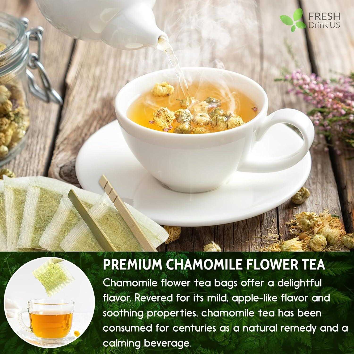 White ceramic cup with steaming chamomile tea and floating chamomile flowers being poured from white teapot on wooden table