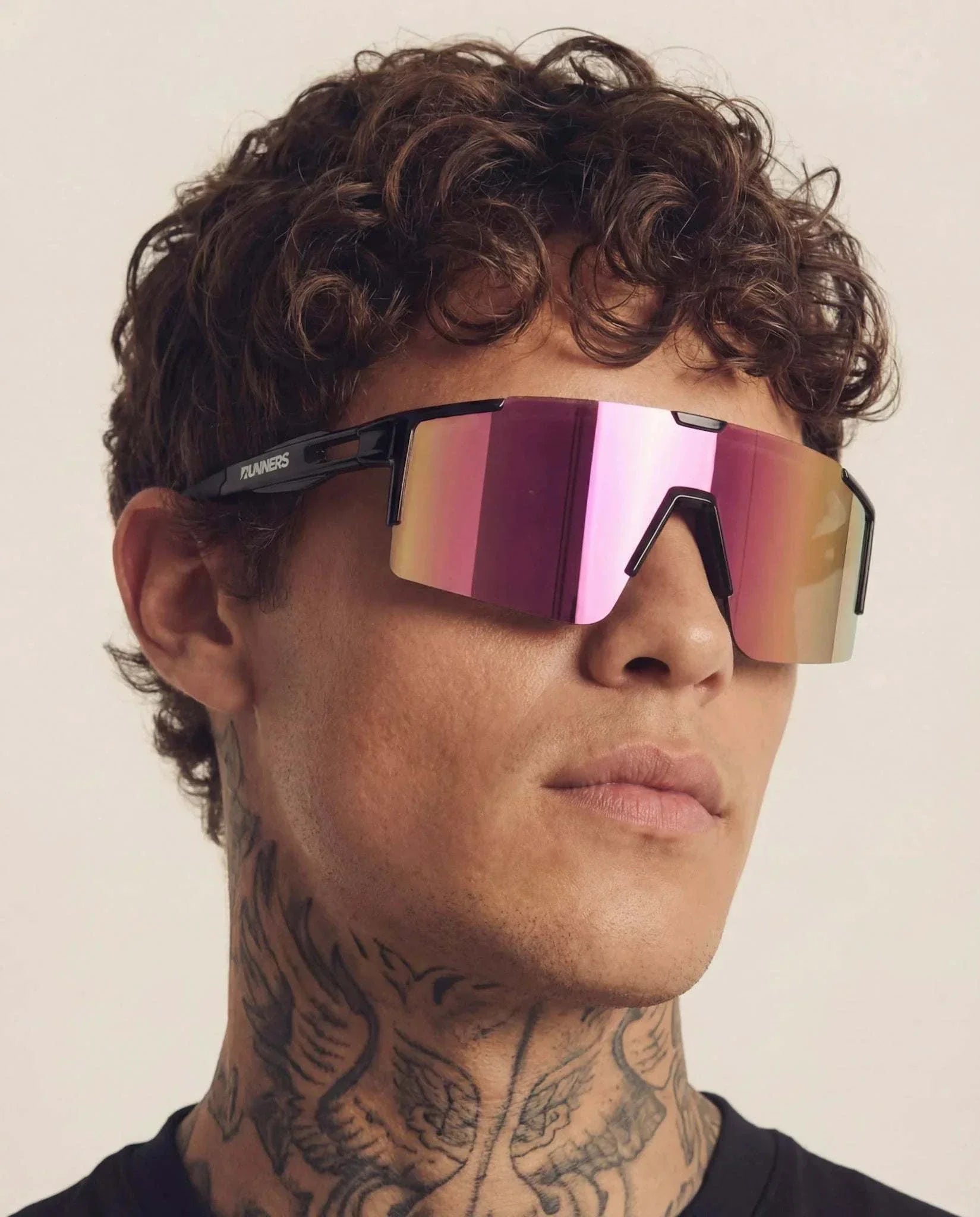 Cherry Pink Polarized Sunglasses with a frameless mirrored pink visor lens and slim black temples, worn by a model