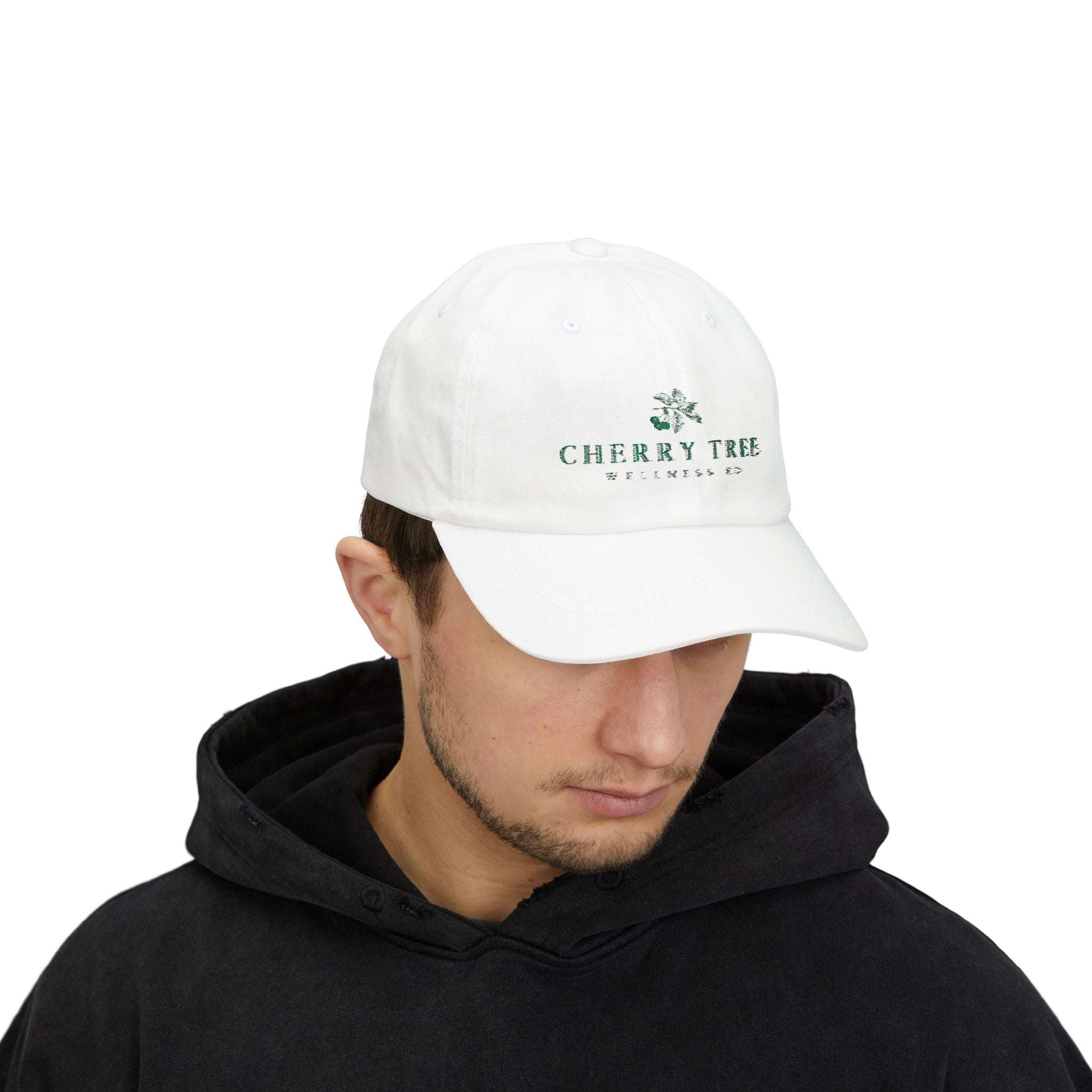 Dad Cap in white cotton with embroidered green Cherry Tree Wellness Co. logo on front, featuring a low-profile, unstructured crown and curved visor.