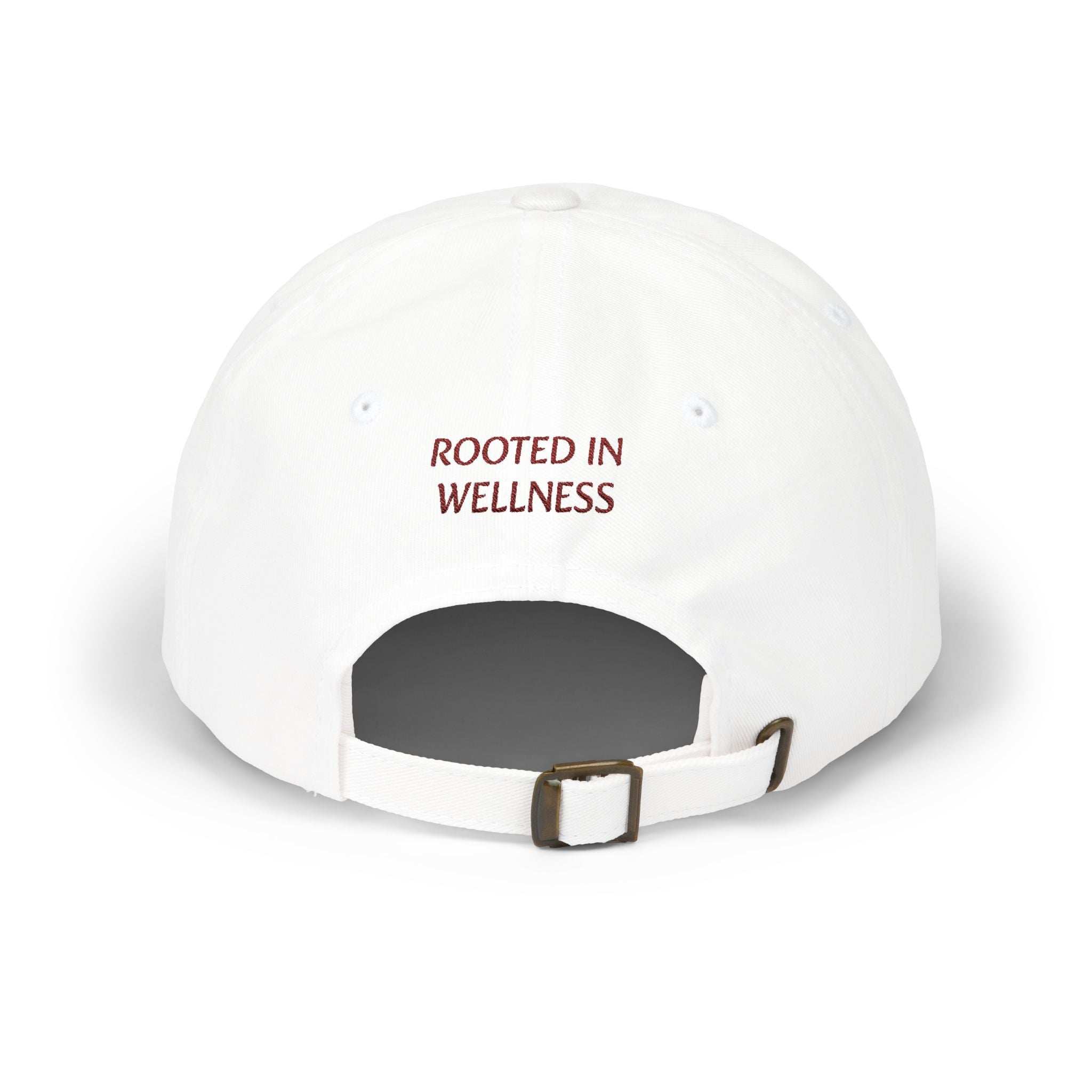 Dad Cap in white cotton with adjustable strap and embroidered "Rooted in Wellness" text on the back in red lettering