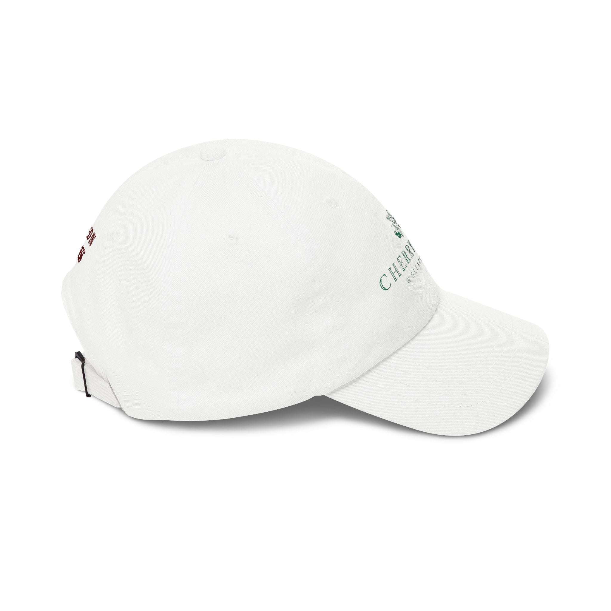 Dad Cap in white cotton with embroidered green Cherry Tree logo, subtle red text on the side, and adjustable strap with brass buckle.