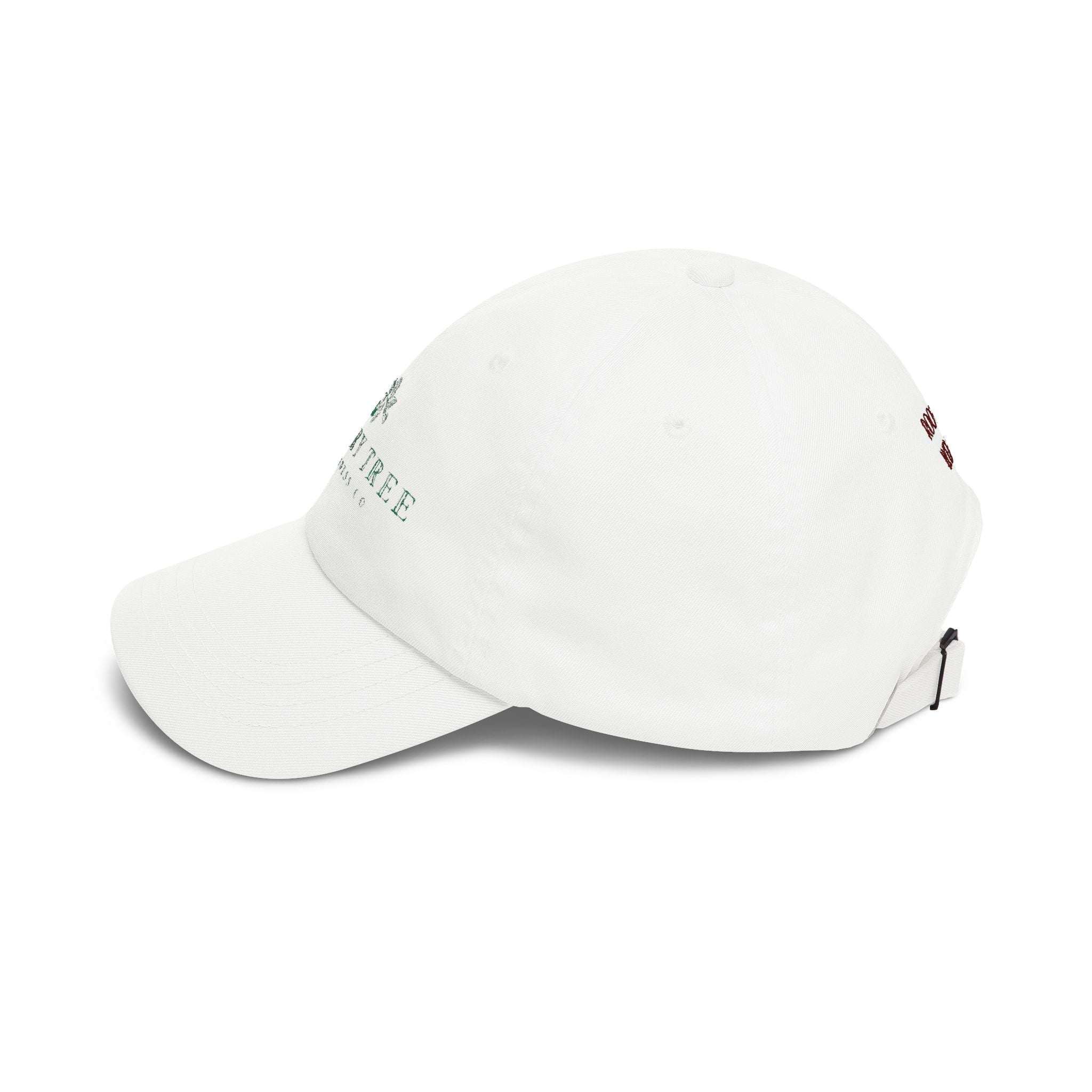 Dad Cap in off-white cotton with embroidered green Cherry Tree logo on front and subtle back text, adjustable strap with brass buckle.
