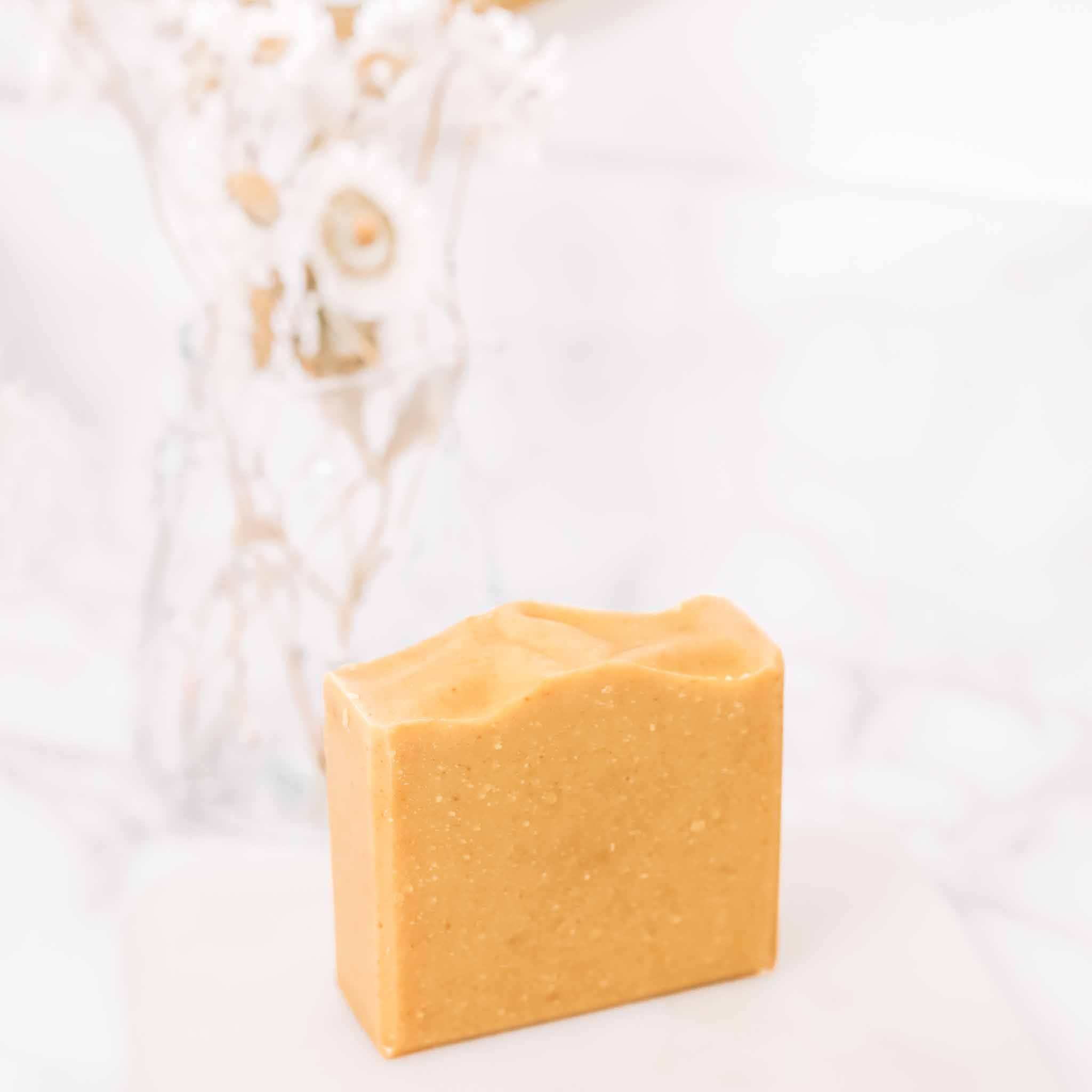 Dark Spot Brightening Kit featuring a translucent amber-orange bar of vitamin C soap with a textured surface