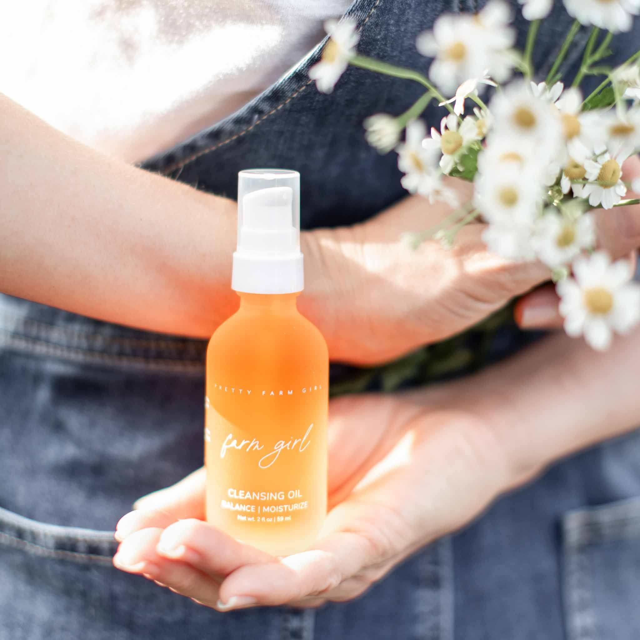 Dark Spot Brightening Kit featuring an orange Farm Girl cleansing oil bottle with white pump and script label