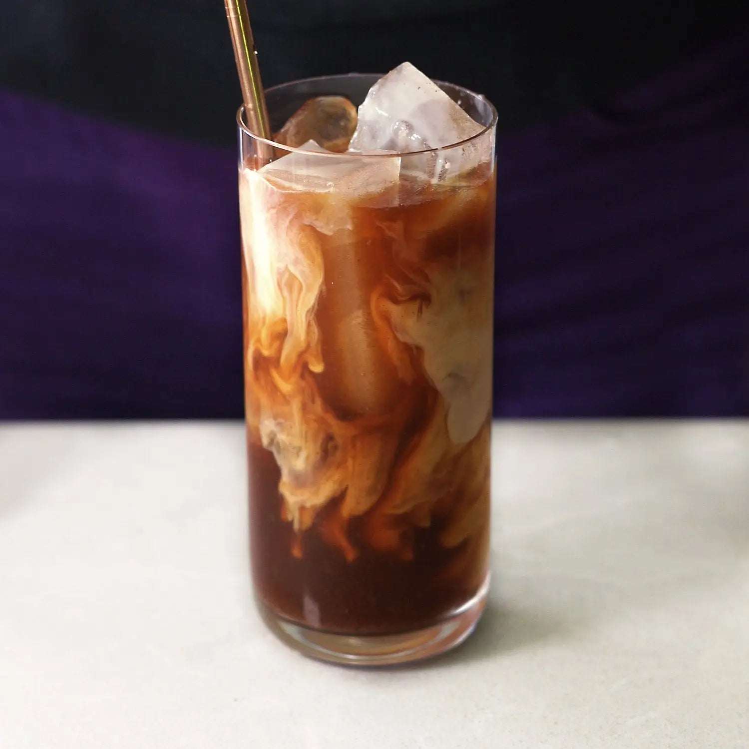 Daybreak - Sweet Roasted Coffee Alternative shown as a dark iced drink with swirling cream and ice in a clear glass