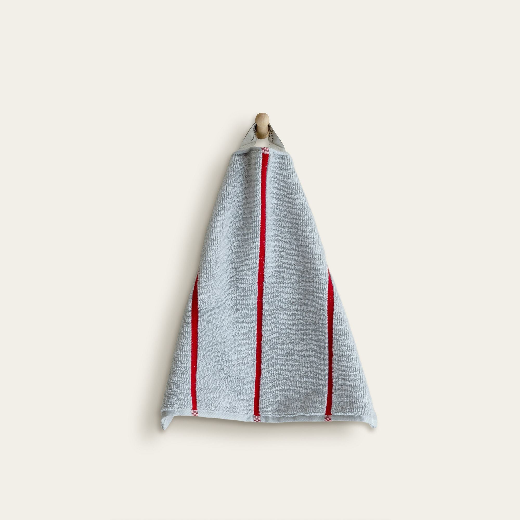 Deia Australian Cotton towel in soft gray with three bold red vertical stripes and a plush textured weave