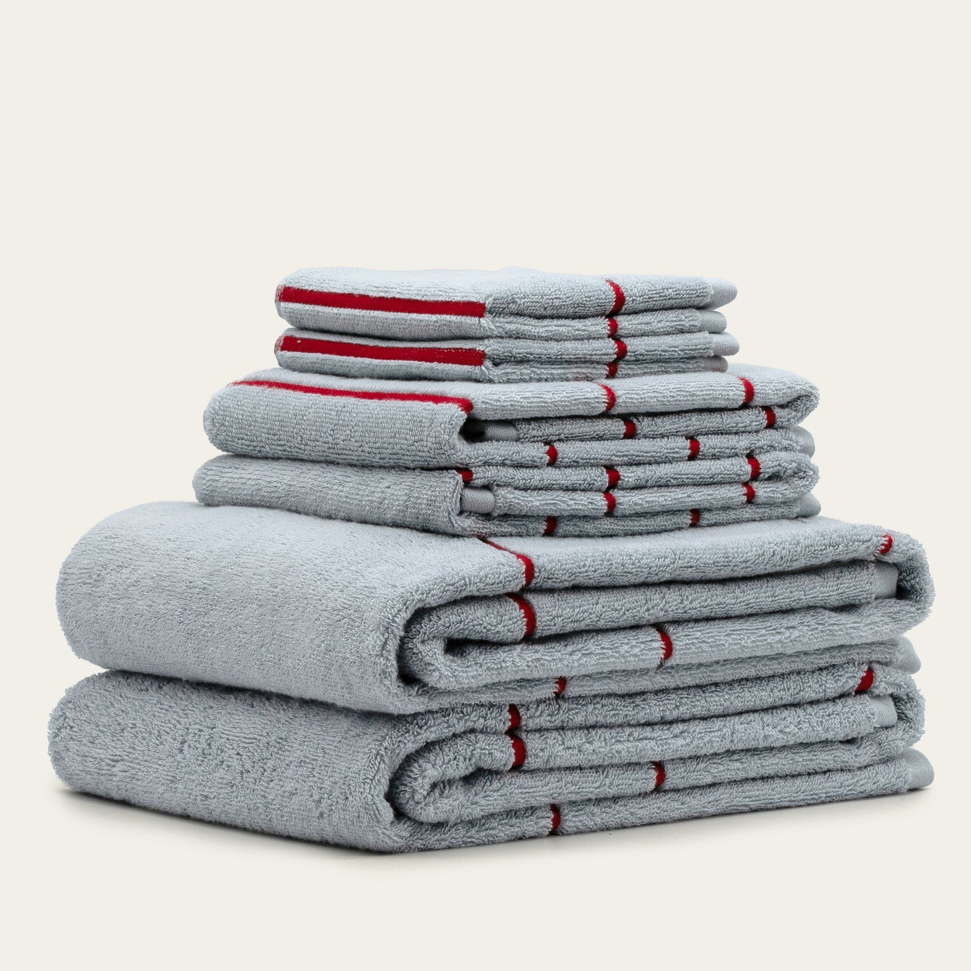 Deia Australian Cotton towels in soft gray plush cotton with distinctive red stripe accents and neatly folded sizes