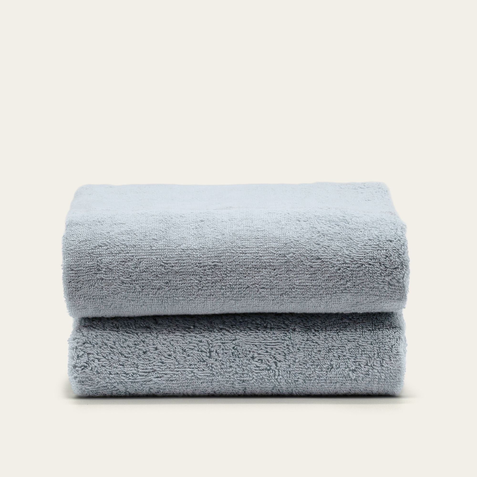Deia Australian Cotton towels in soft pale blue, plush textured cotton pile, folded into a neat stack