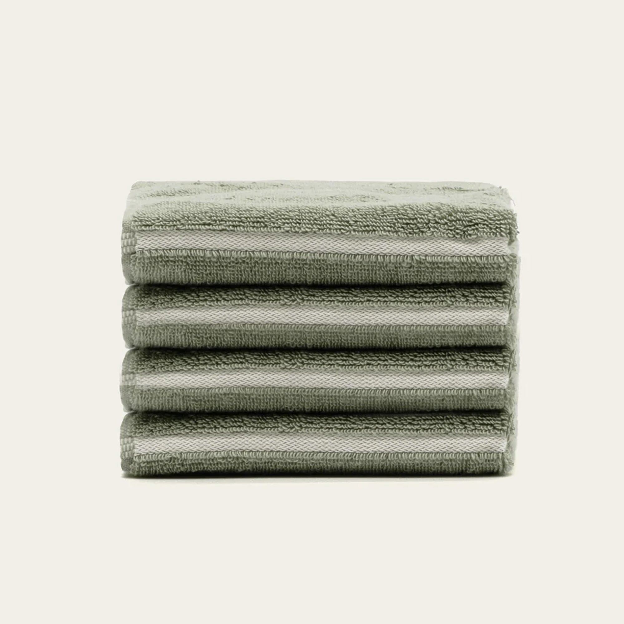 Towels in Deia Australian Cotton, soft sage green with plush terry texture and subtle woven stripe borders