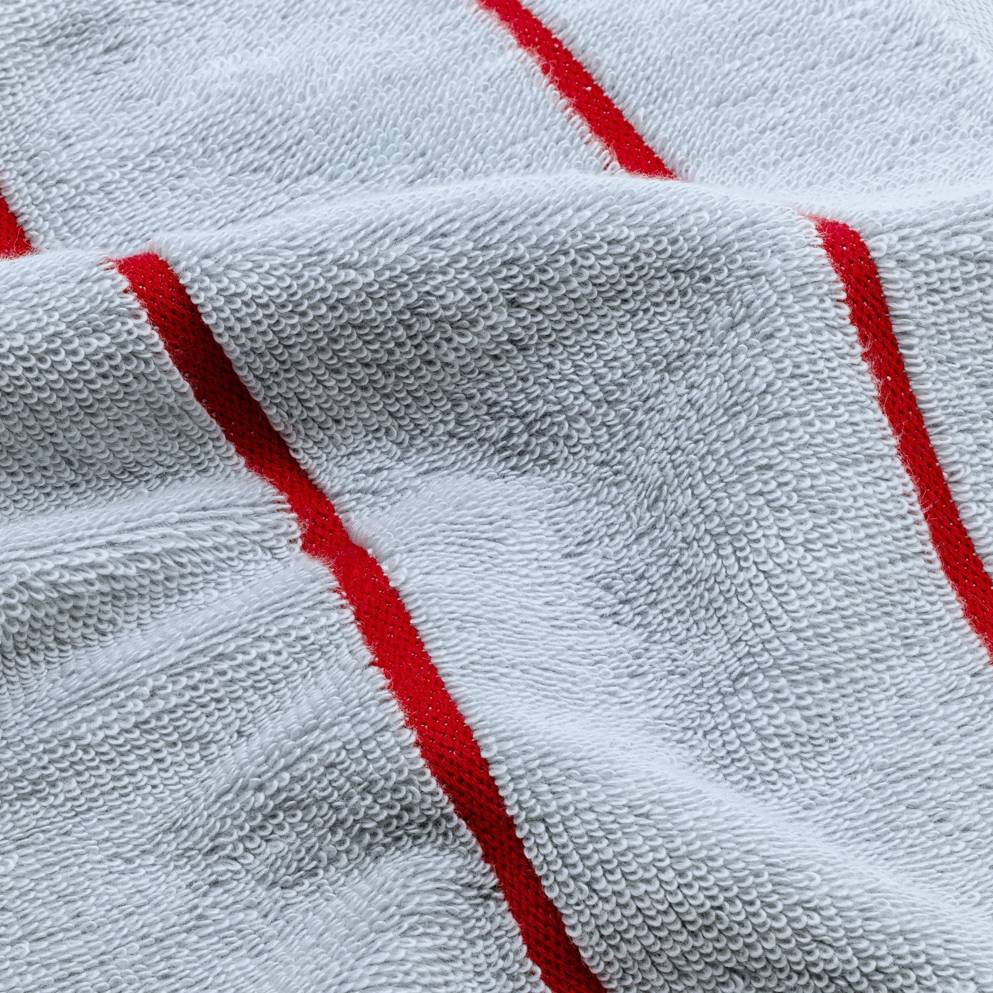 Deia Australian Cotton towel in white, with plush looped terry texture and bold red woven stripe accents