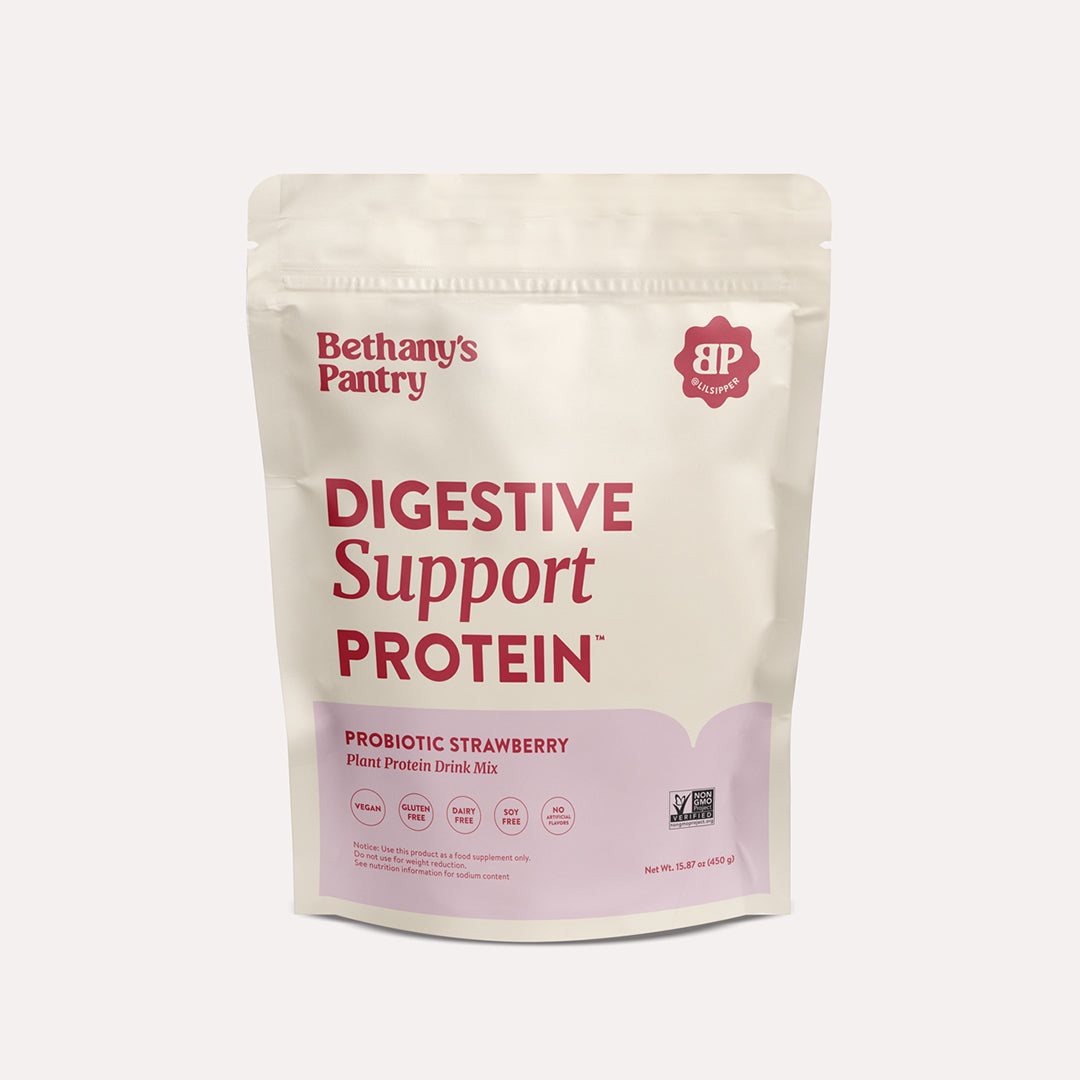 Digestive Support Protein pouch in cream and pale pink, with red lettering and probiotic strawberry plant protein drink mix label