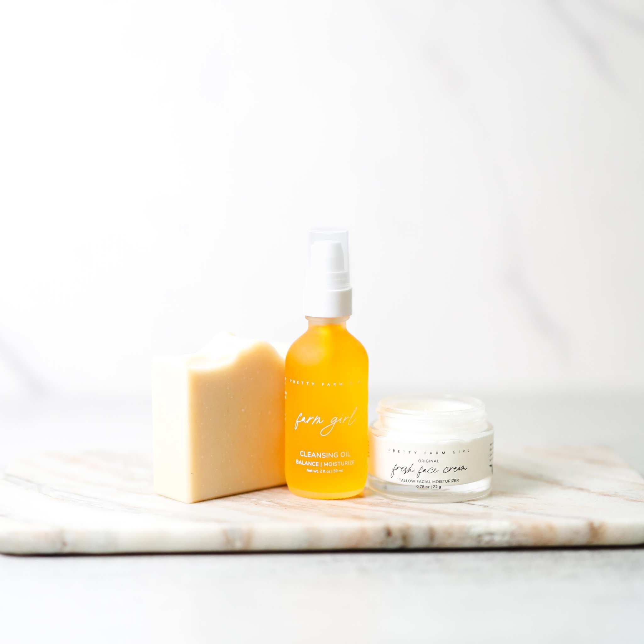 Double Cleansing Anti Aging Kit with cream soap bar, amber cleansing oil bottle, and white face cream jar