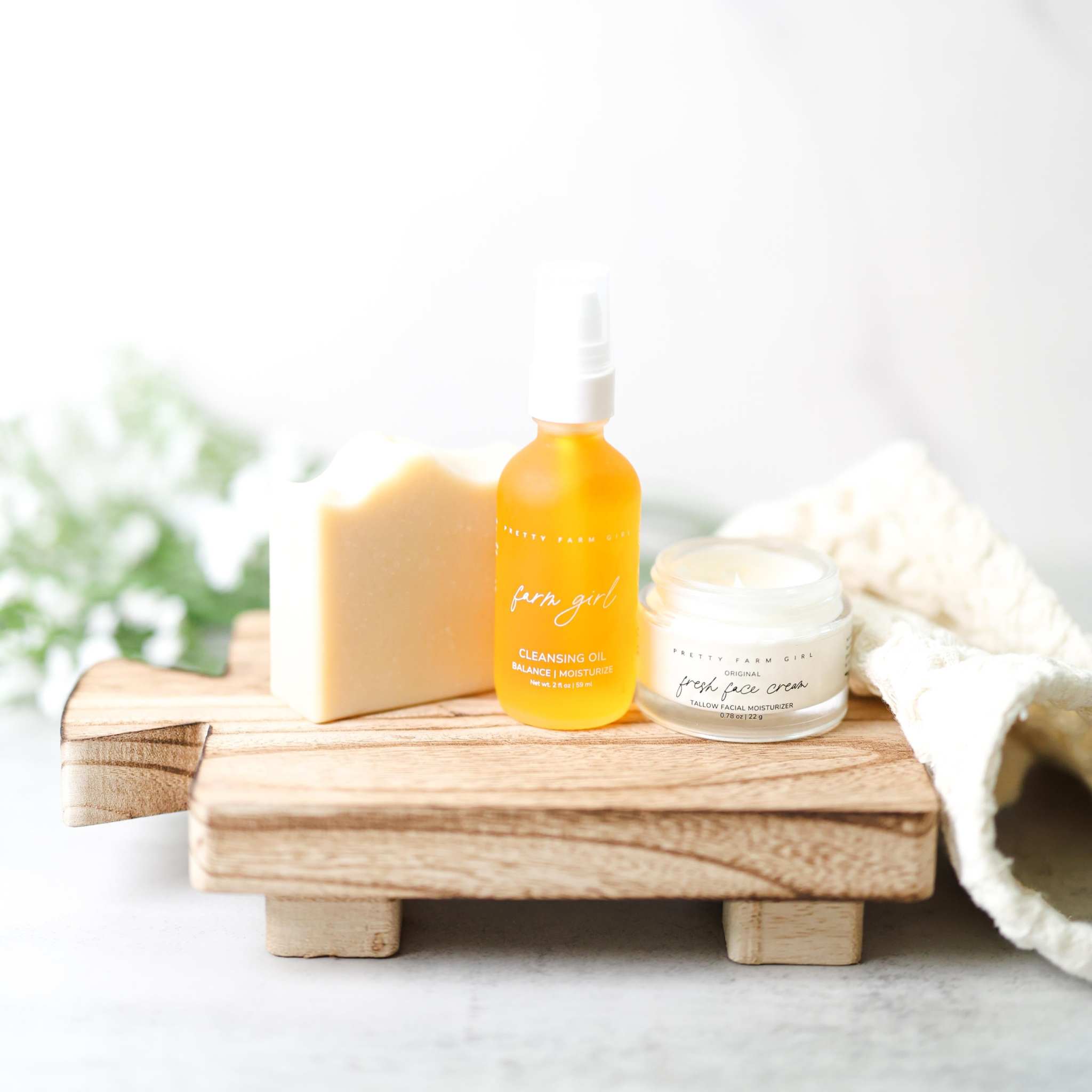 Double Cleansing Anti Aging Kit with cream soap bar, orange cleansing oil bottle, and Fresh Face Cream jar