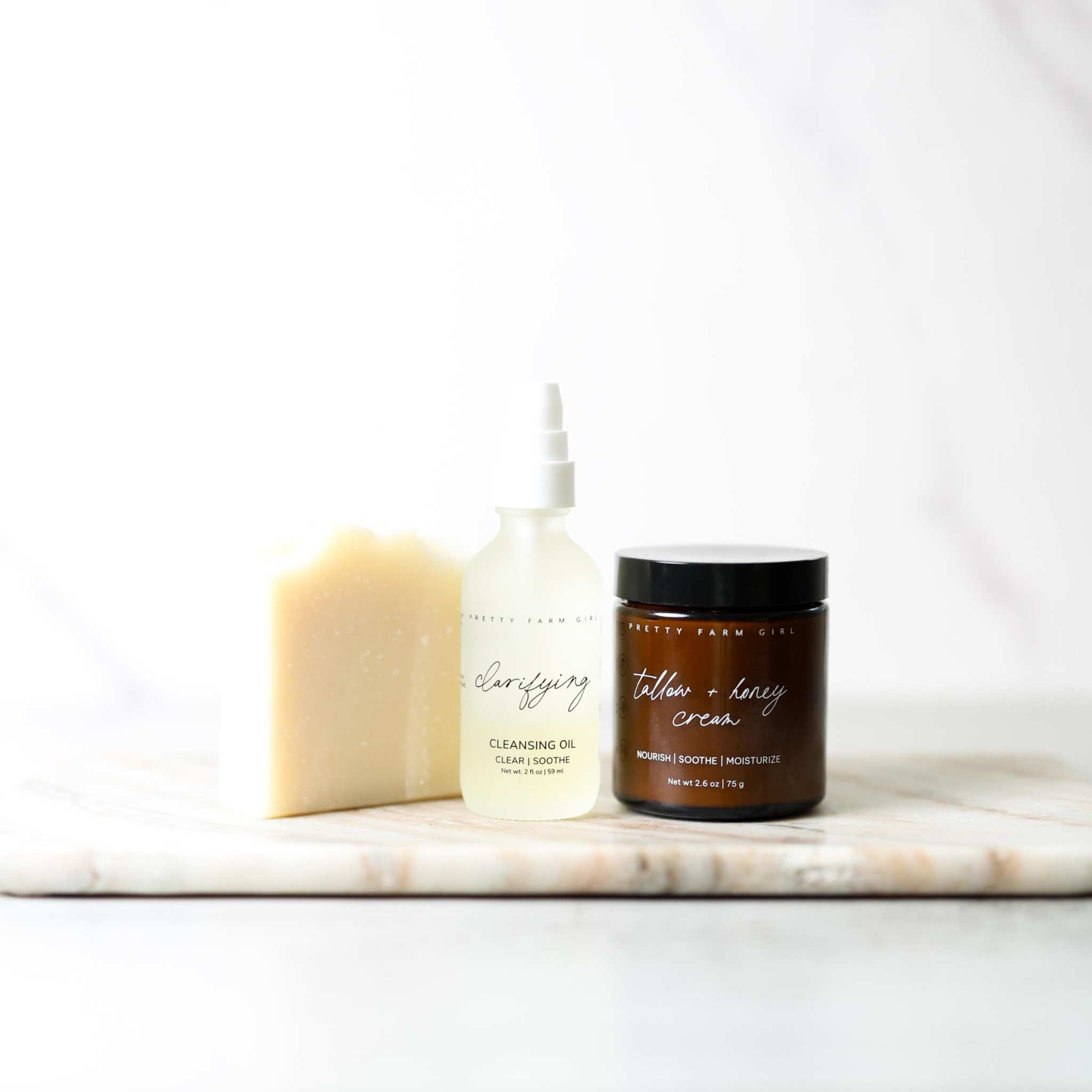 Double Cleansing Kit Soothing with cream soap bar, white cleansing oil bottle, and dark glass tallow honey cream jar