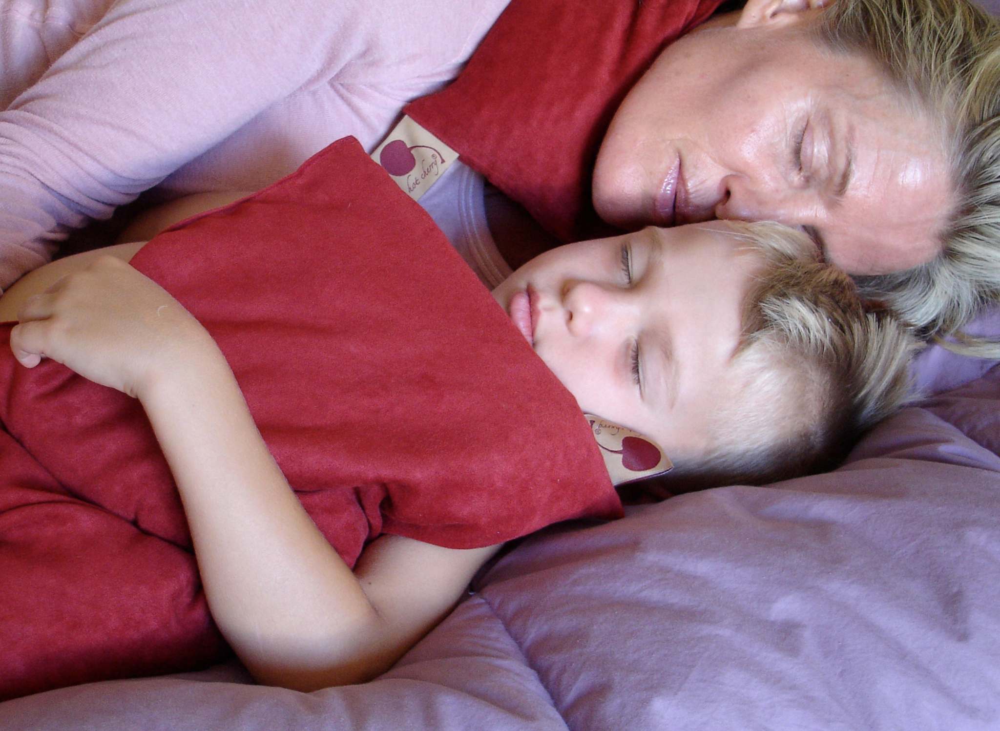 Double Square Pillow in red plush fabric, a soft rectangular cushion held against a child while resting