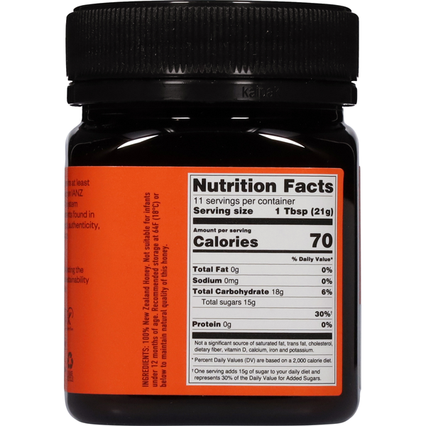 Egmont Manuka Honey in a dark jar with a bright orange label and black ribbed screw cap, showing nutrition facts.