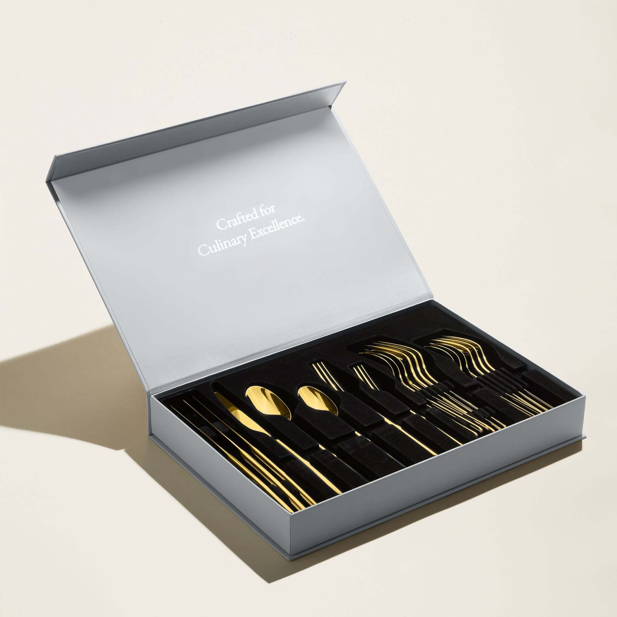 Emilia Mirror 20-Piece Flatware Set with polished gold-tone stainless steel cutlery arranged in a presentation box