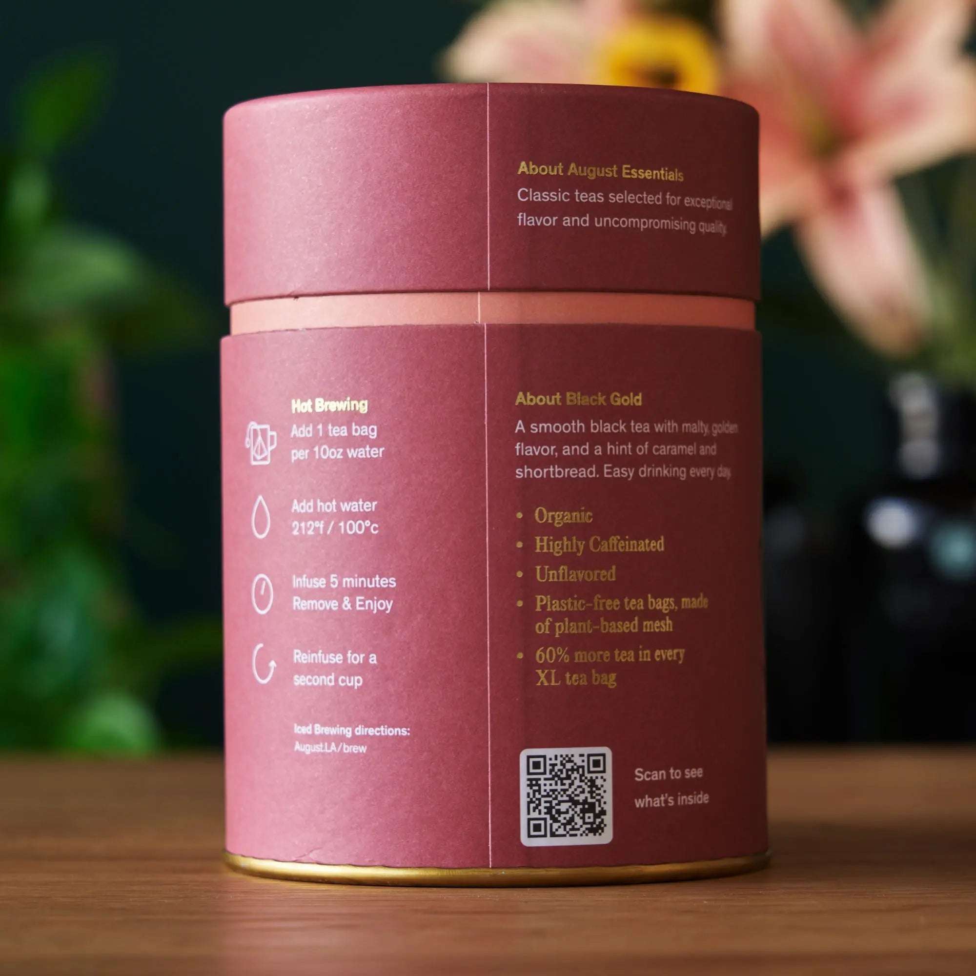 Essentials Black Tea in a pink and burgundy cylindrical tin, with gold text and brewing instructions