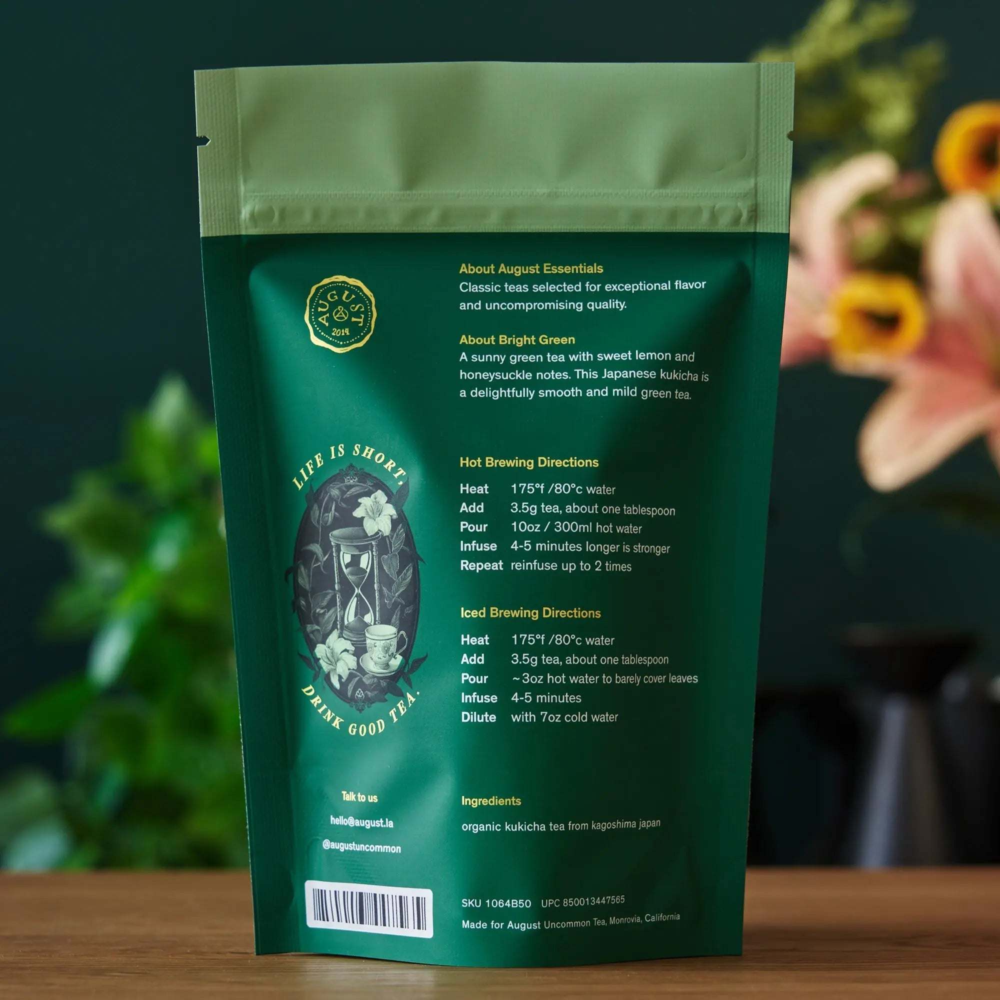 Essentials Bright Green Tea in a dark green resealable pouch, featuring gold botanical artwork and brewing details